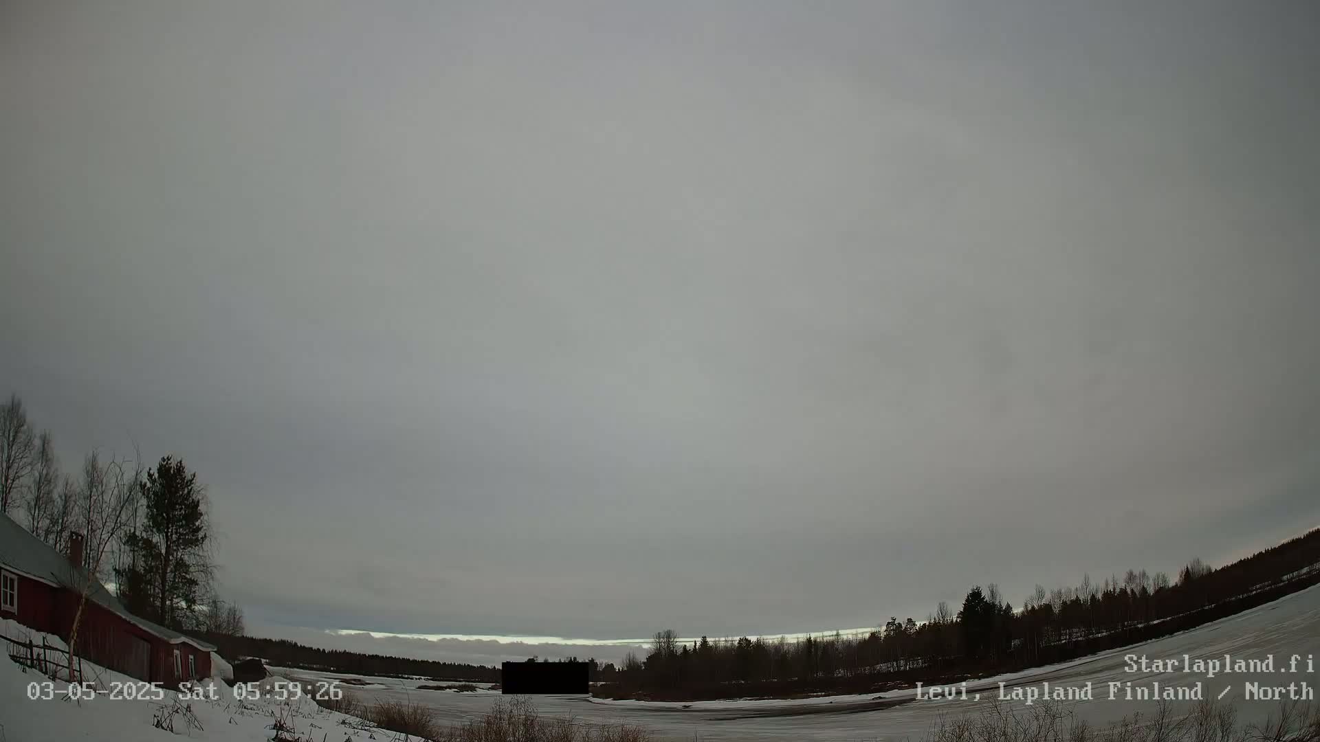 A snow-covered landscape with a red building and trees is visible under an overcast sky.