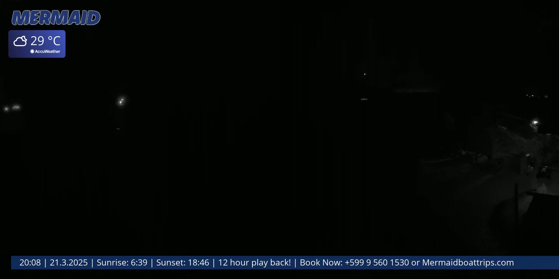 A dark, nighttime scene shows faintly illuminated areas and what appears to be snow on the ground under cloudy skies, with a temperature of 29°C.