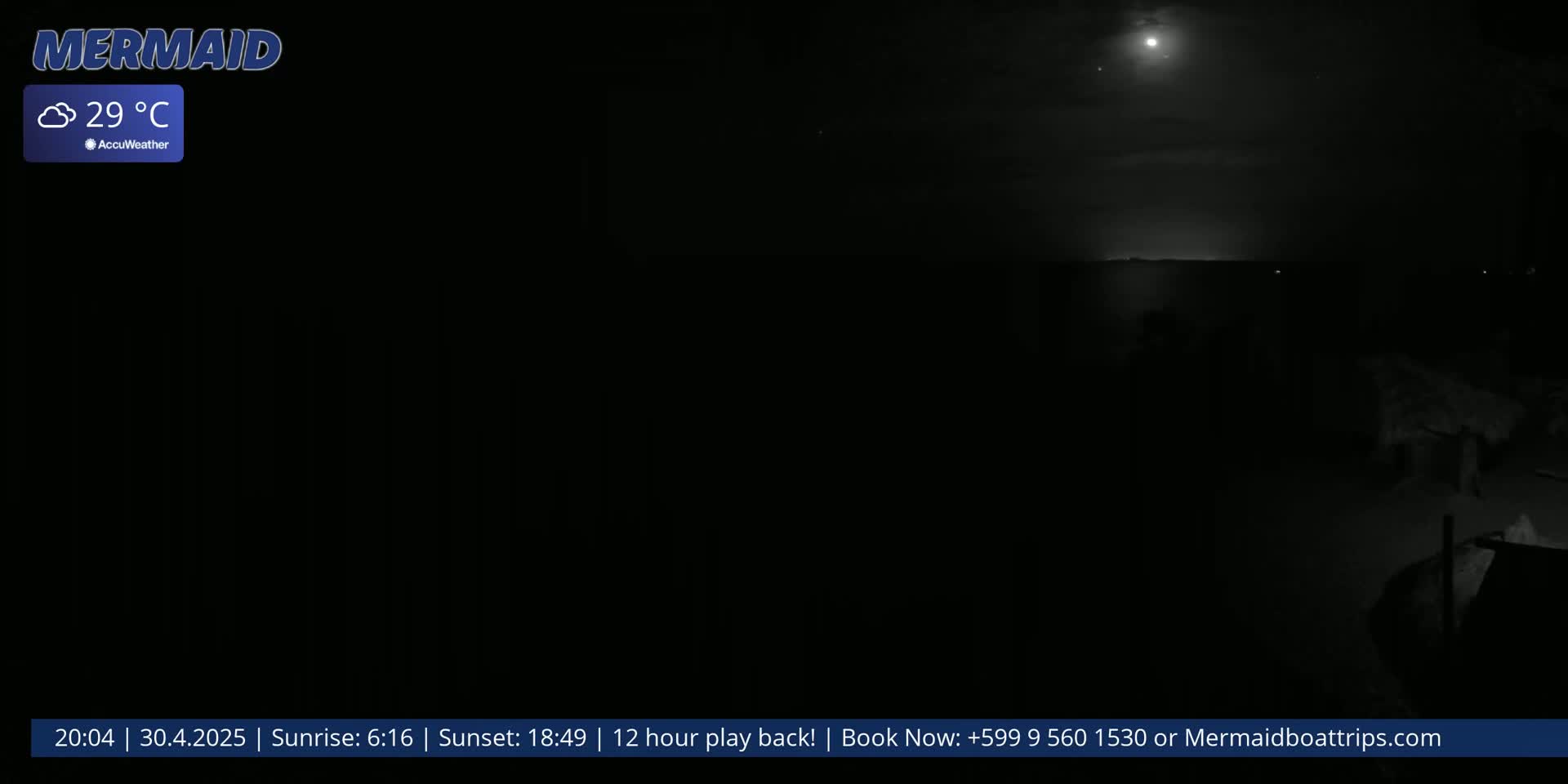 A nighttime, cloudy scene shows a dark body of water under a bright moon.