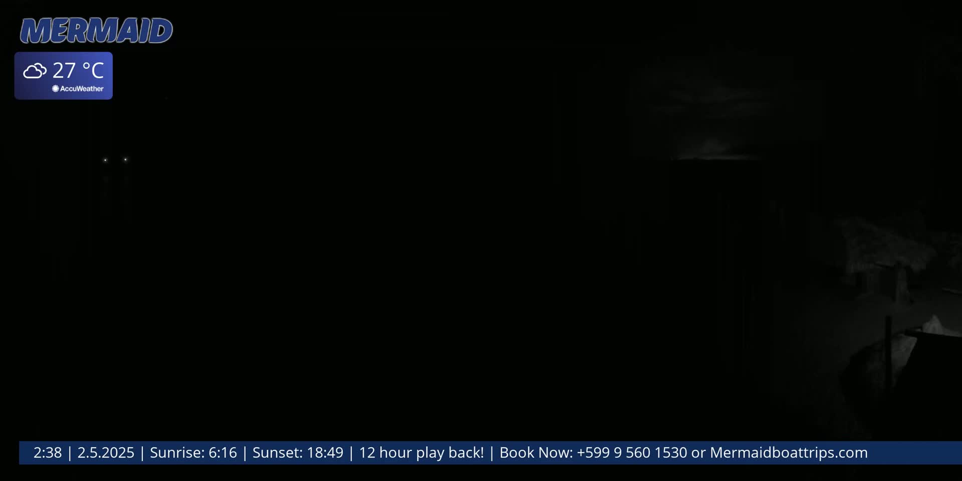 A mostly dark nighttime scene with a few faint lights visible in the distance, and a cloudy sky.