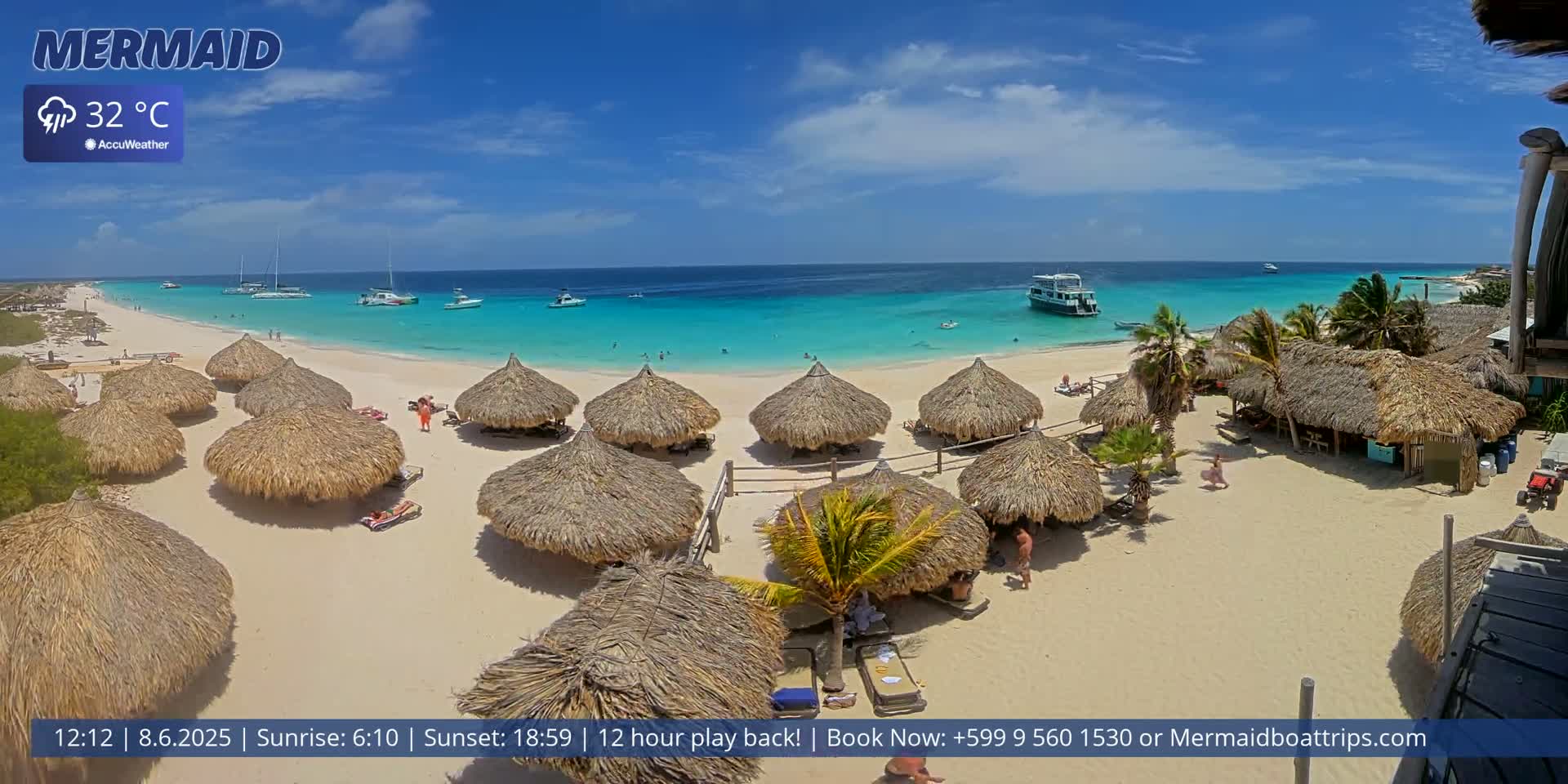 A sunny beach with turquoise water, numerous thatched umbrellas, and several boats offshore.