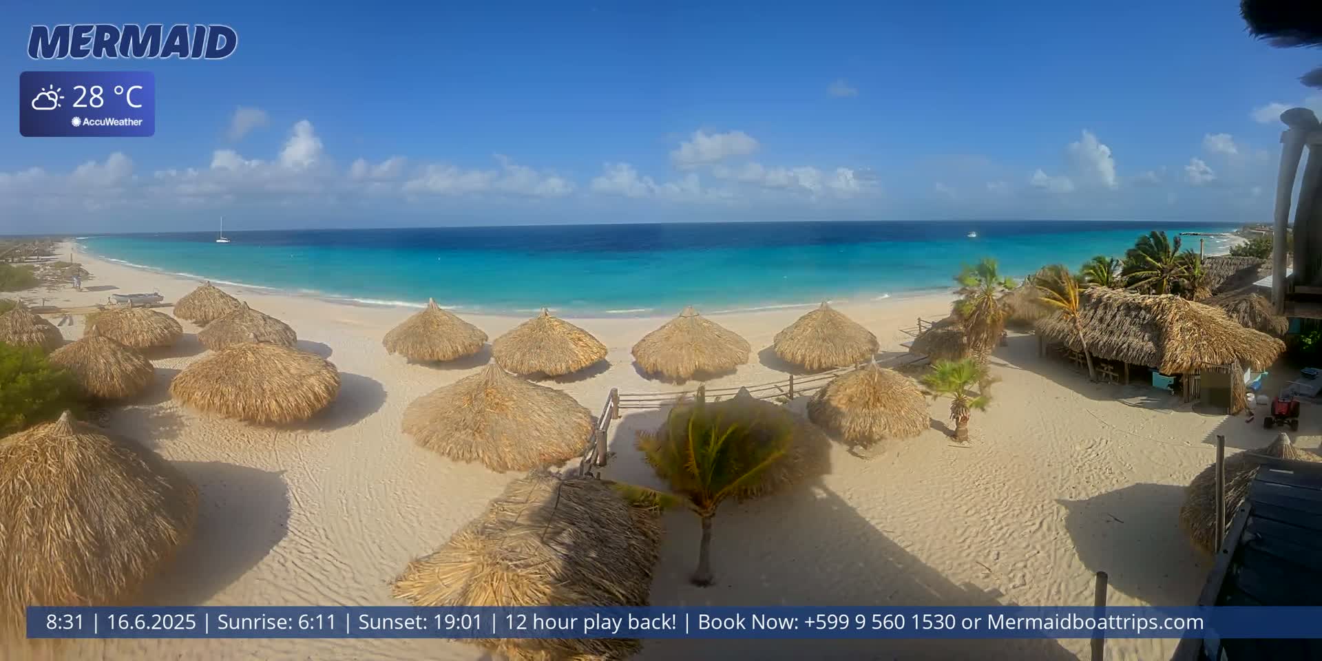 A beach with numerous thatched-roof huts and turquoise water under a mostly sunny sky.