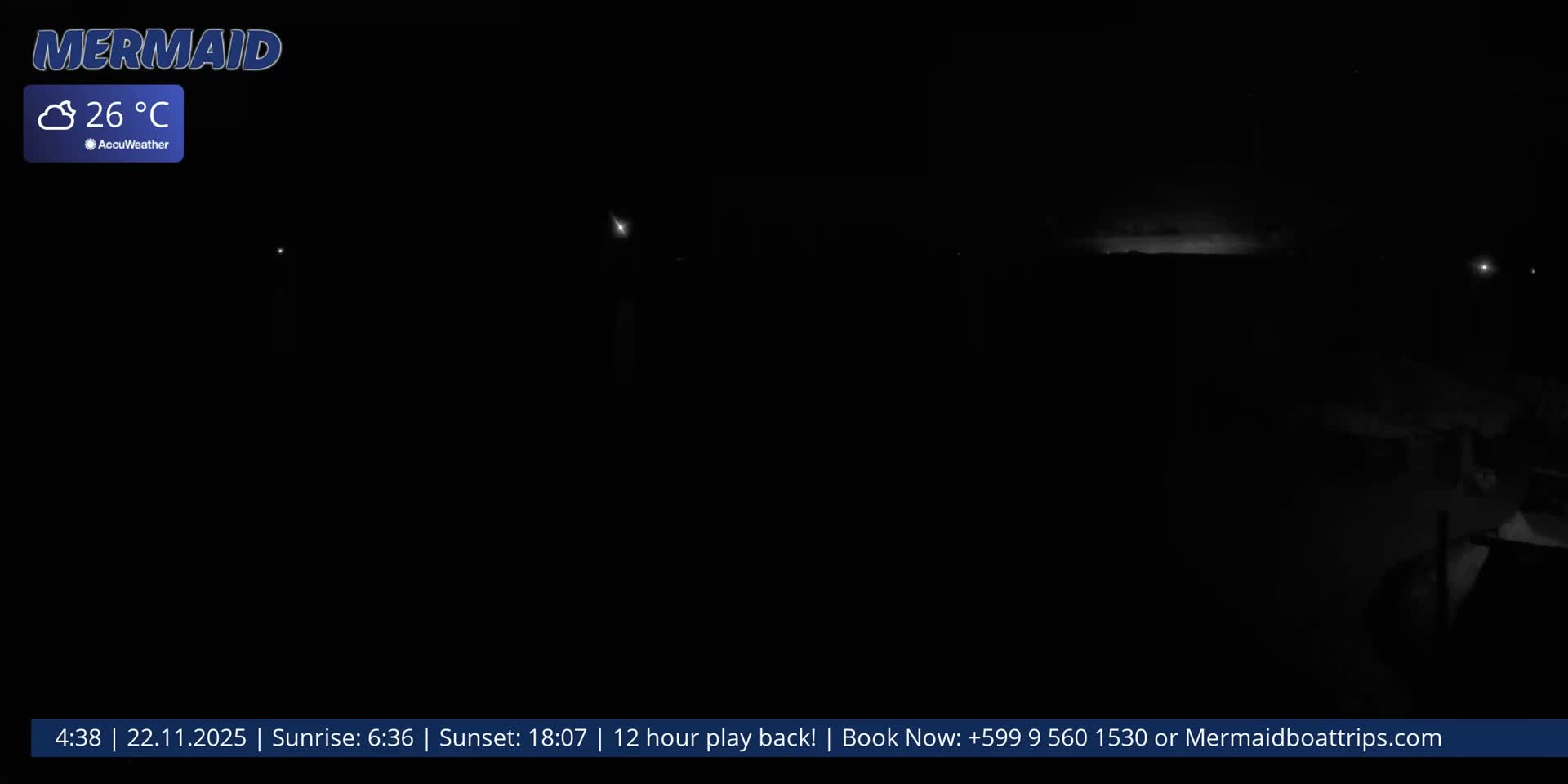 The image depicts a very dark outdoor scene at night with faint distant lights, under partly cloudy skies at 26 degrees Celsius.