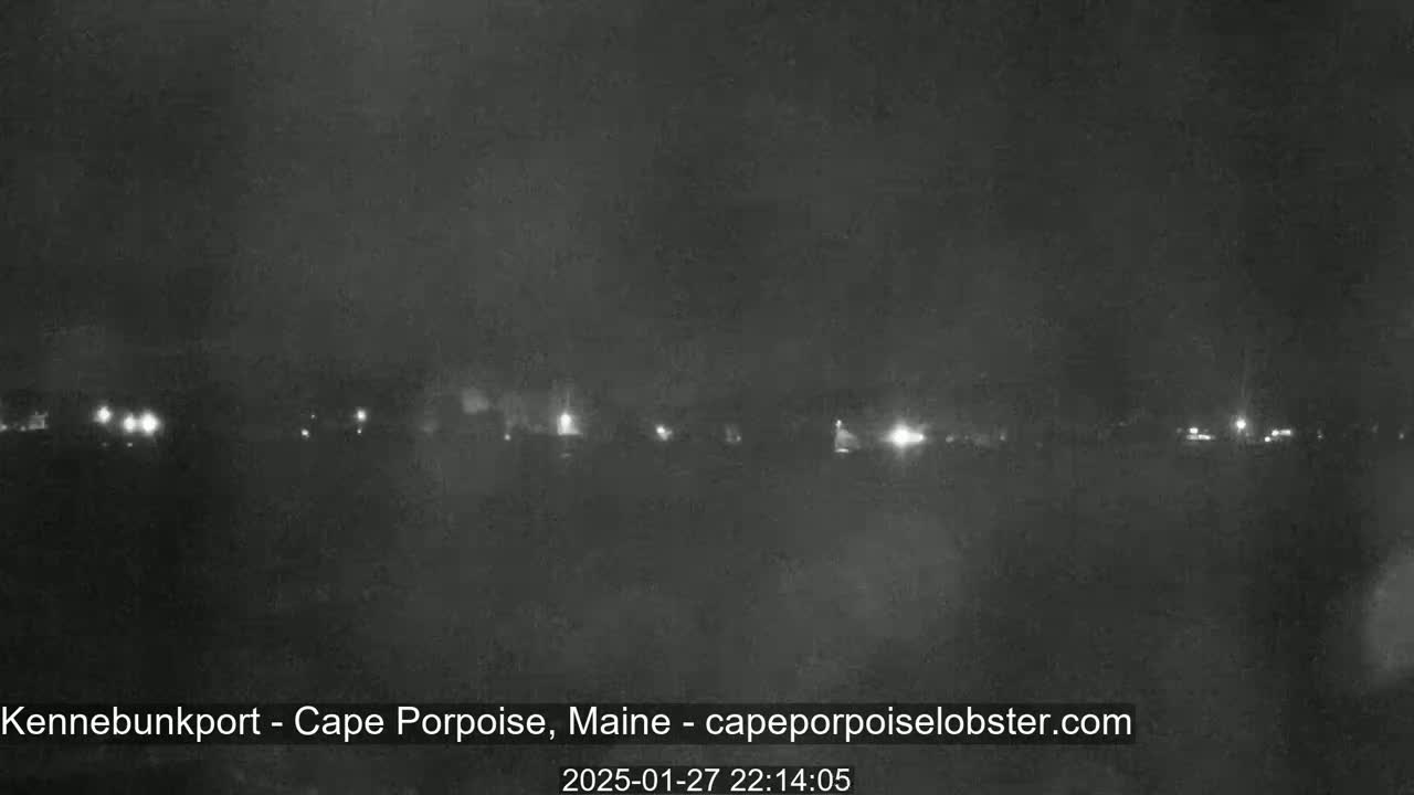 A nighttime, hazy view shows a line of distant lights across a dark landscape.