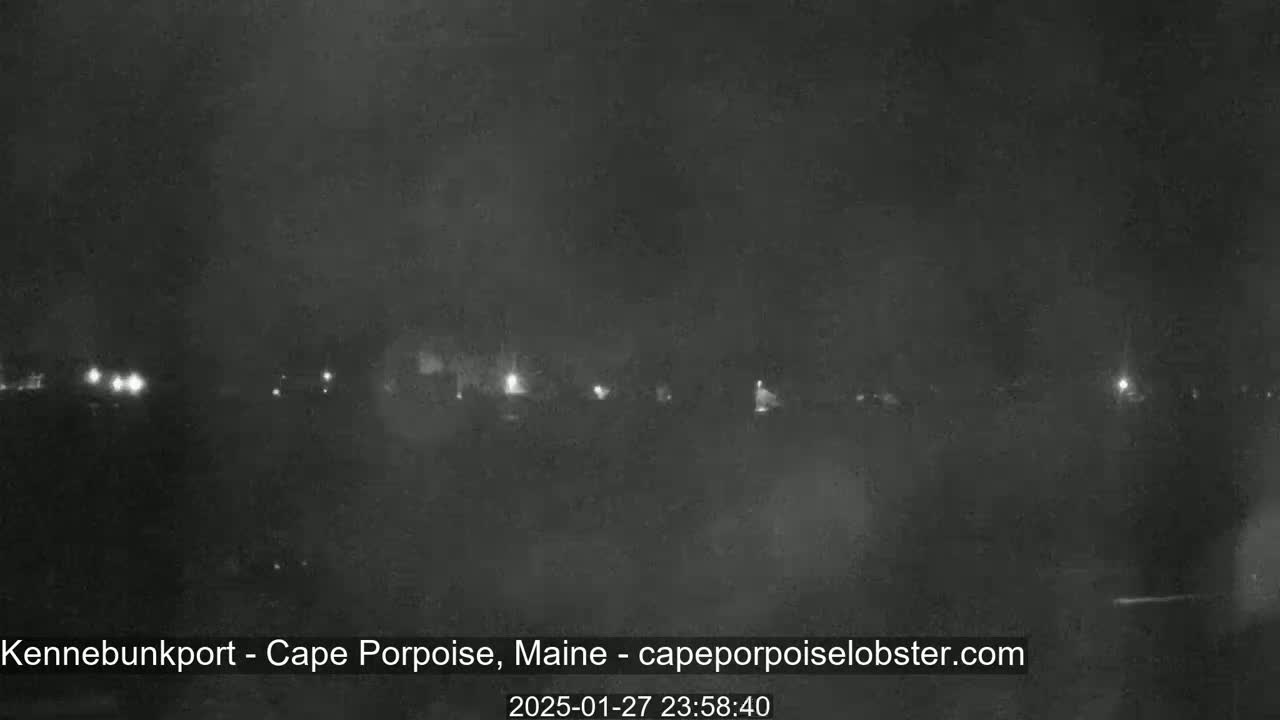 A nighttime, hazy view shows a row of distant lights across a dark landscape.