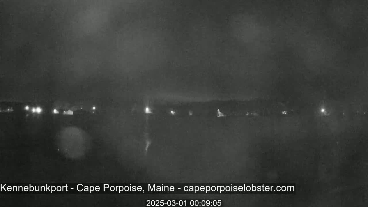 A nighttime, hazy view shows a dark landscape with a few distant lights.