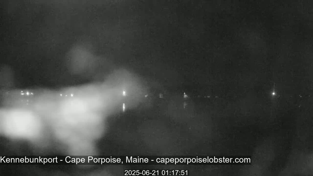 A nighttime, hazy view of a body of water with faint lights on the far shore.