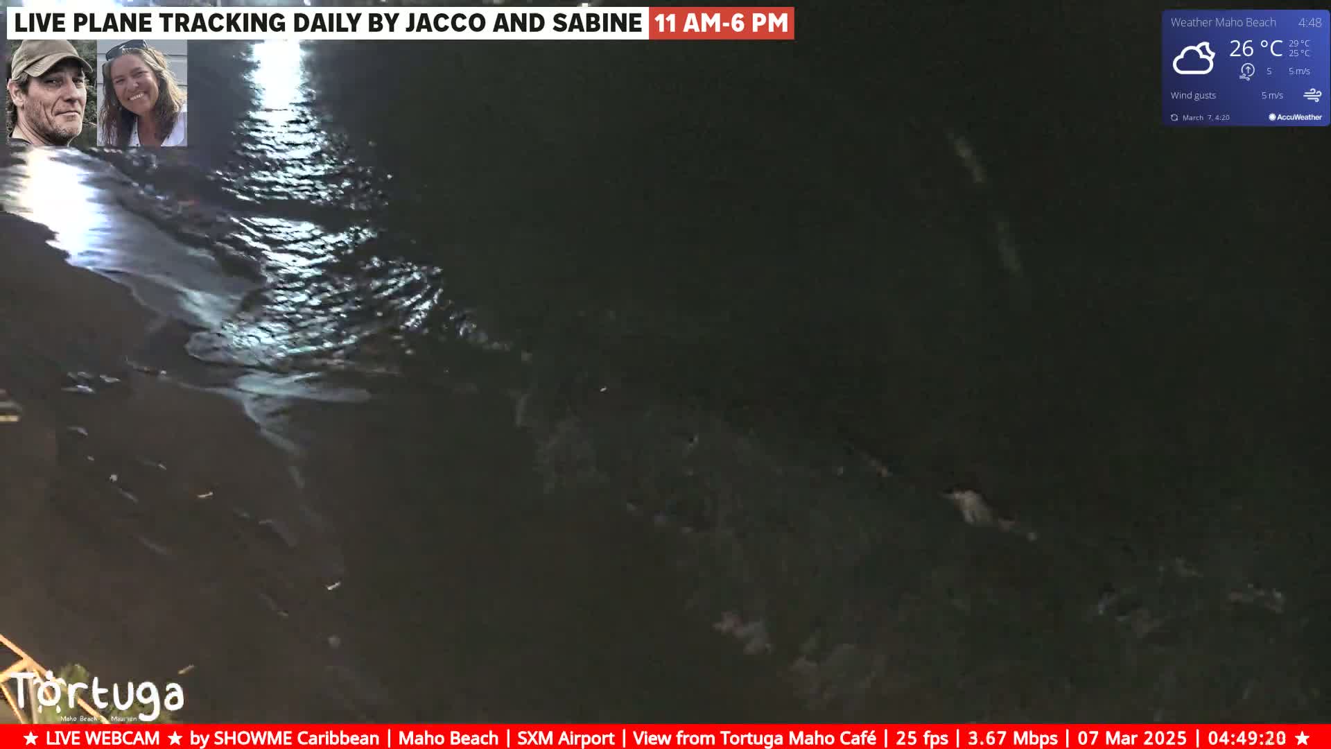 A nighttime, aerial view of dark ocean water with small waves under a partly cloudy sky.