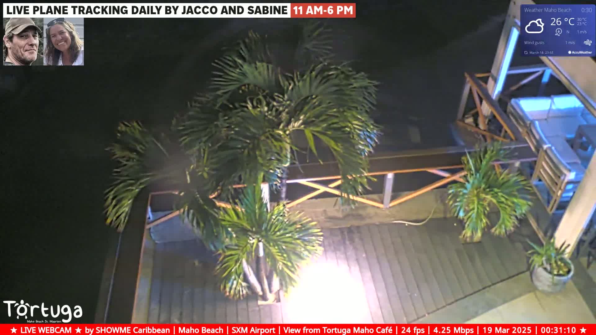 A nighttime outdoor scene shows a patio with palm trees under a clear sky,  a temperature of 26°C.