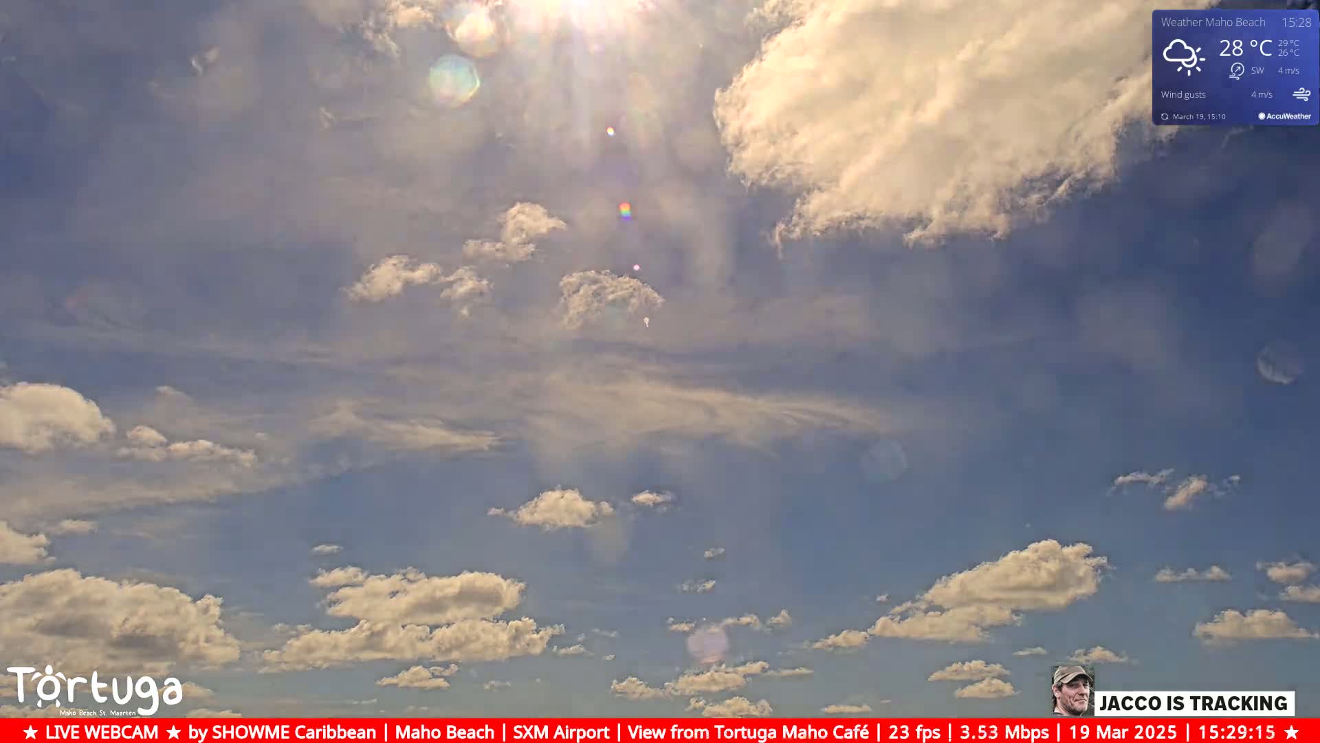 A mostly sunny sky with scattered cumulus clouds under bright sunlight.