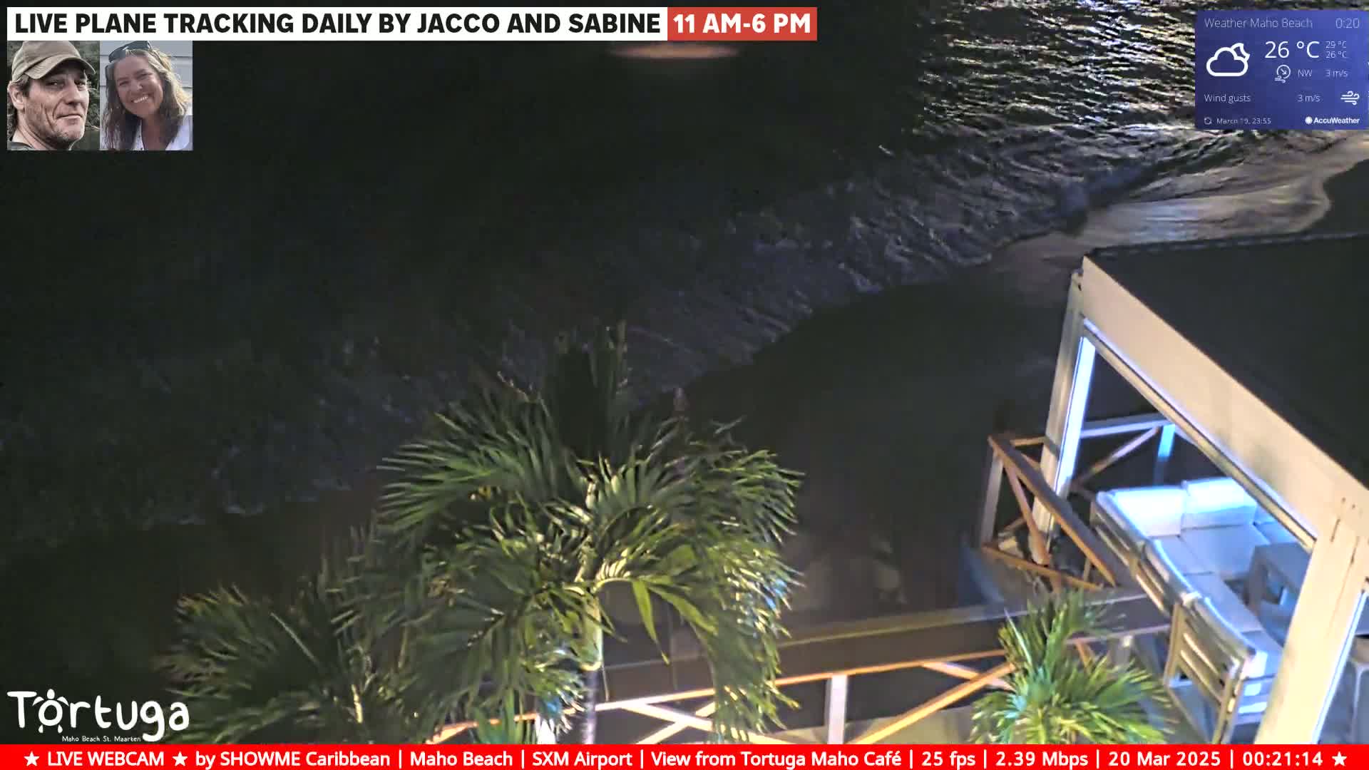 A nighttime beach scene shows dark waves lapping at a shoreline near a partially enclosed outdoor structure with palm trees, under a clear sky with a temperature of 26°C.