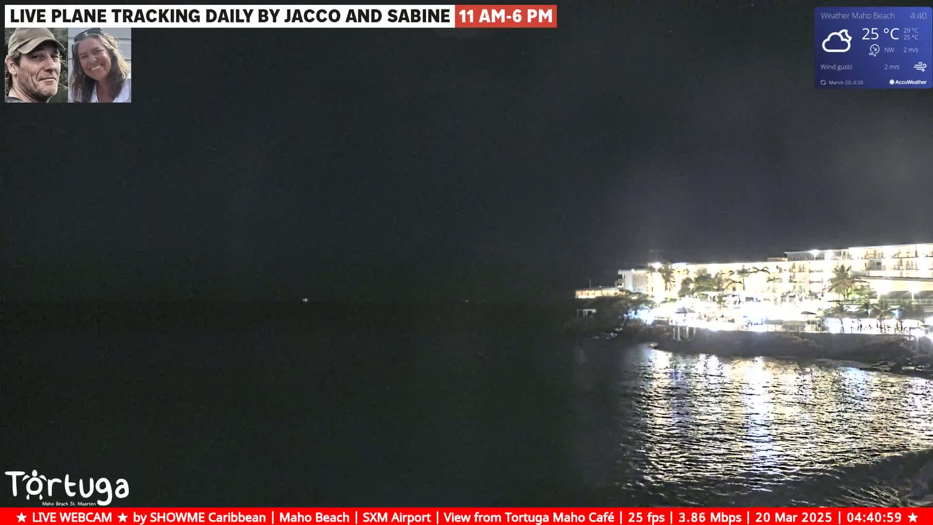 A nighttime view of a resort on a dark ocean under a partly cloudy sky.
