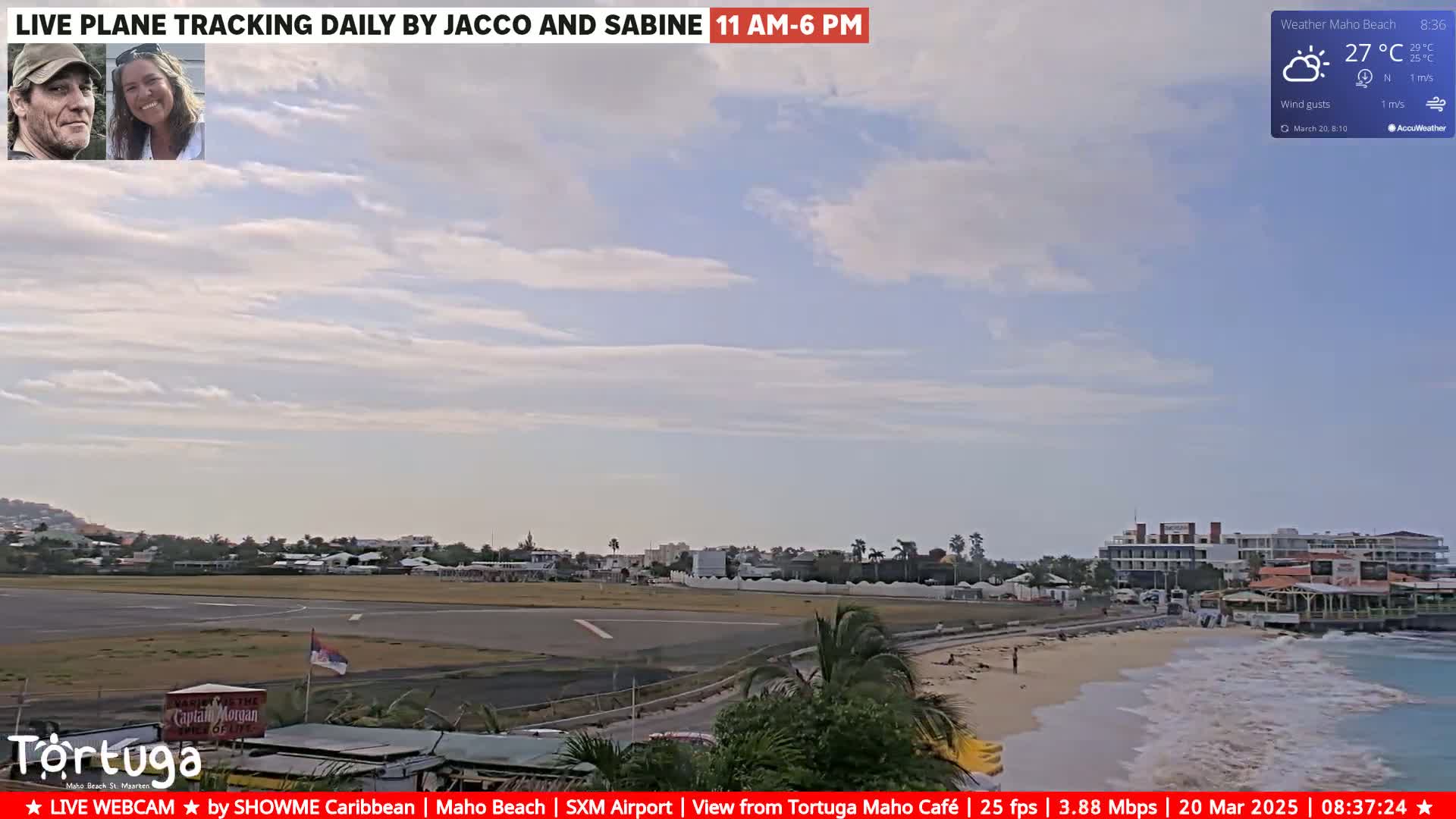 A mostly sunny beach scene shows an airport runway, ocean waves, and a beachfront with buildings under a partly cloudy sky.