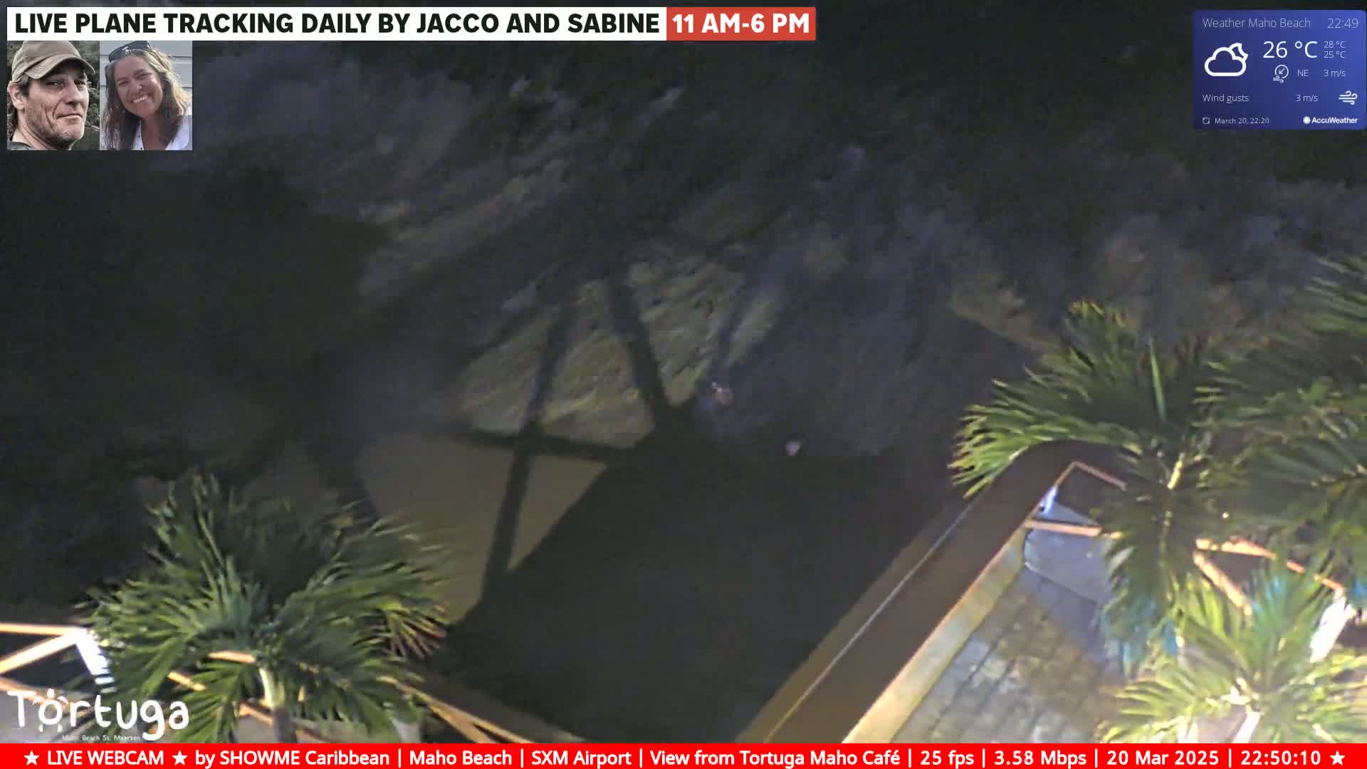 A nighttime, slightly cloudy outdoor scene shows a dark area with some palm trees and a building partially visible, under a temperature of 26°C.