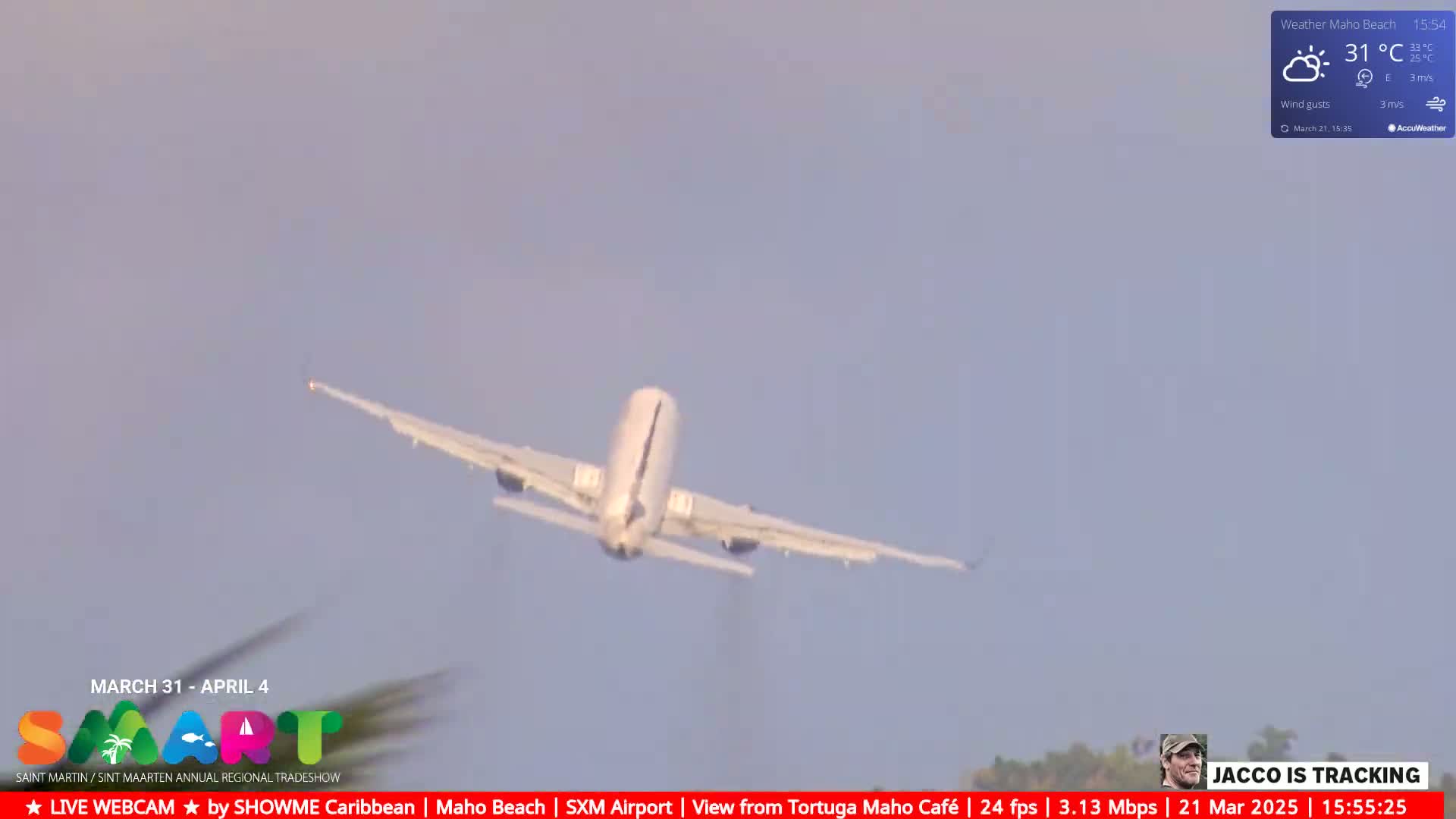 A white passenger airplane is taking off under partly cloudy skies.