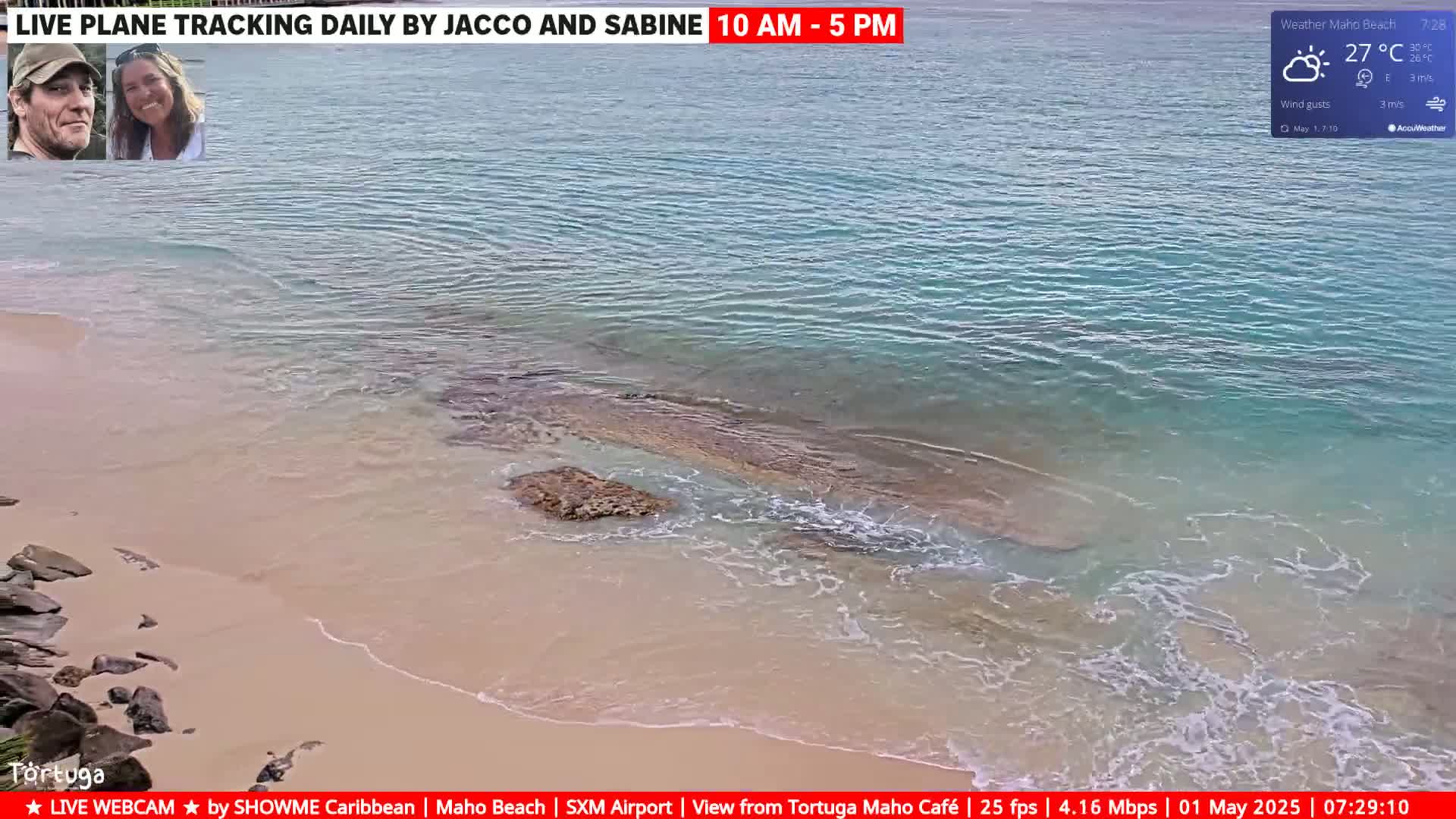 A sandy beach meets calm, light-blue water under partly sunny skies.