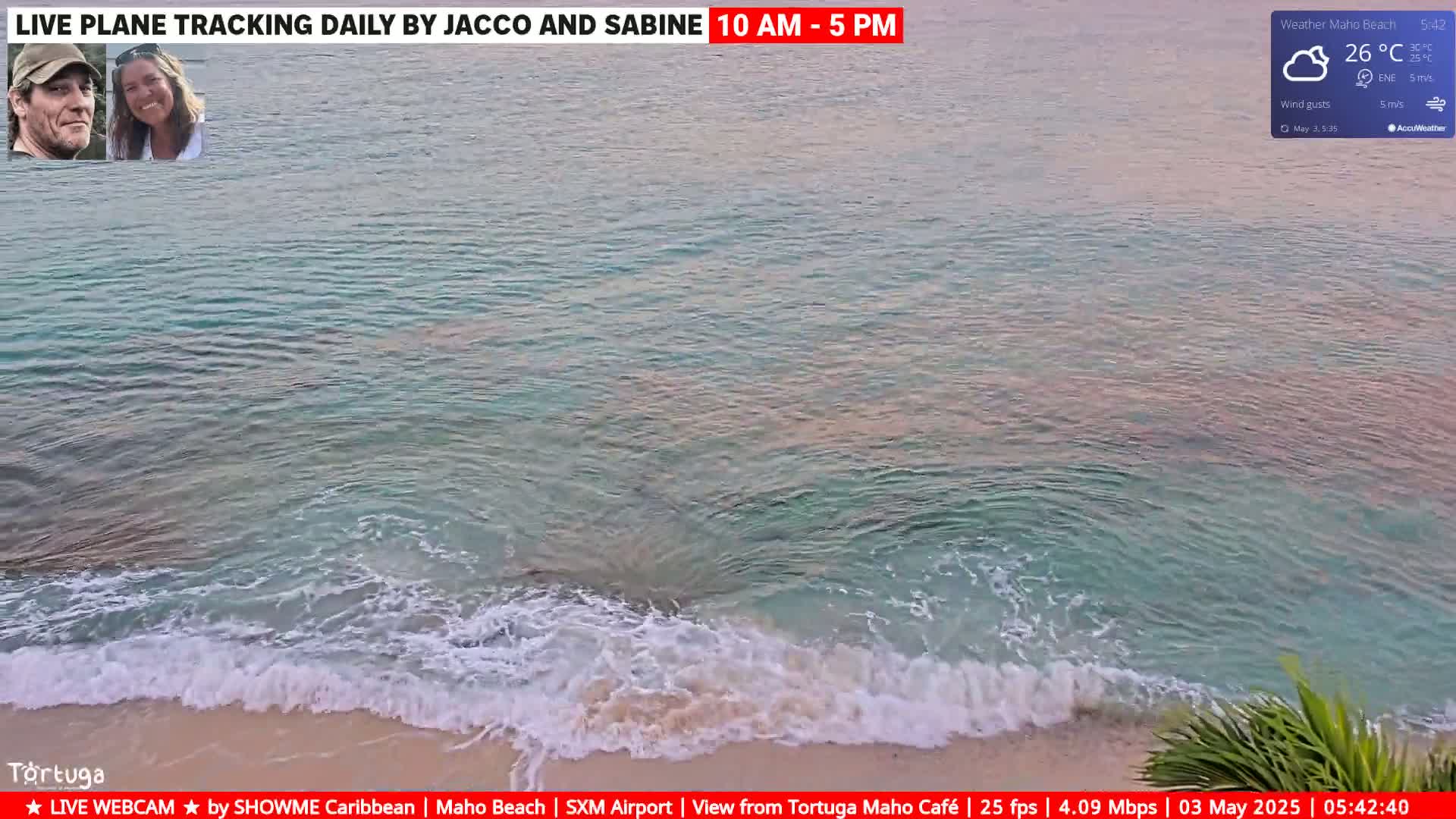 Ocean waves break on a sandy shore under a partly cloudy sky.