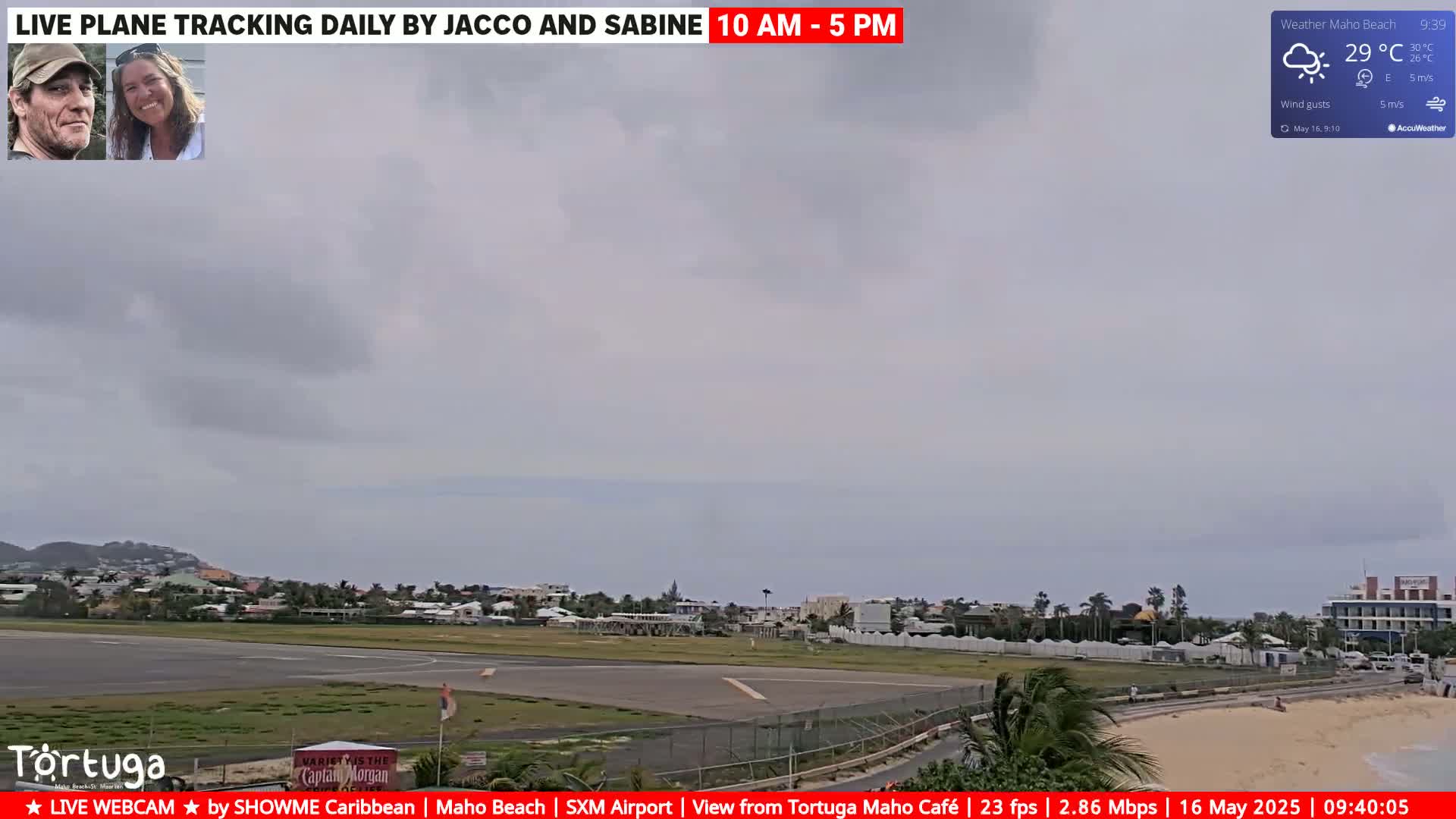 A mostly cloudy sky overlooks an airport runway and beach with calm ocean waves.