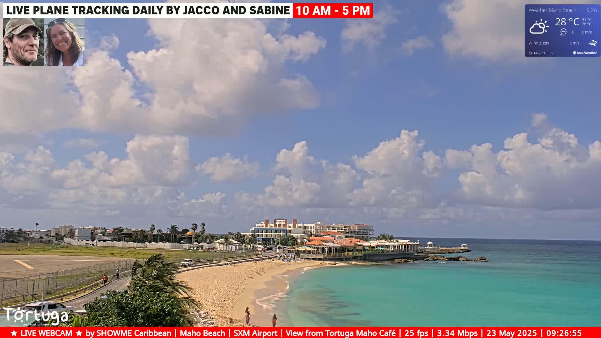A partly cloudy day shows a beach with turquoise water, a restaurant, and part of an airport runway.
