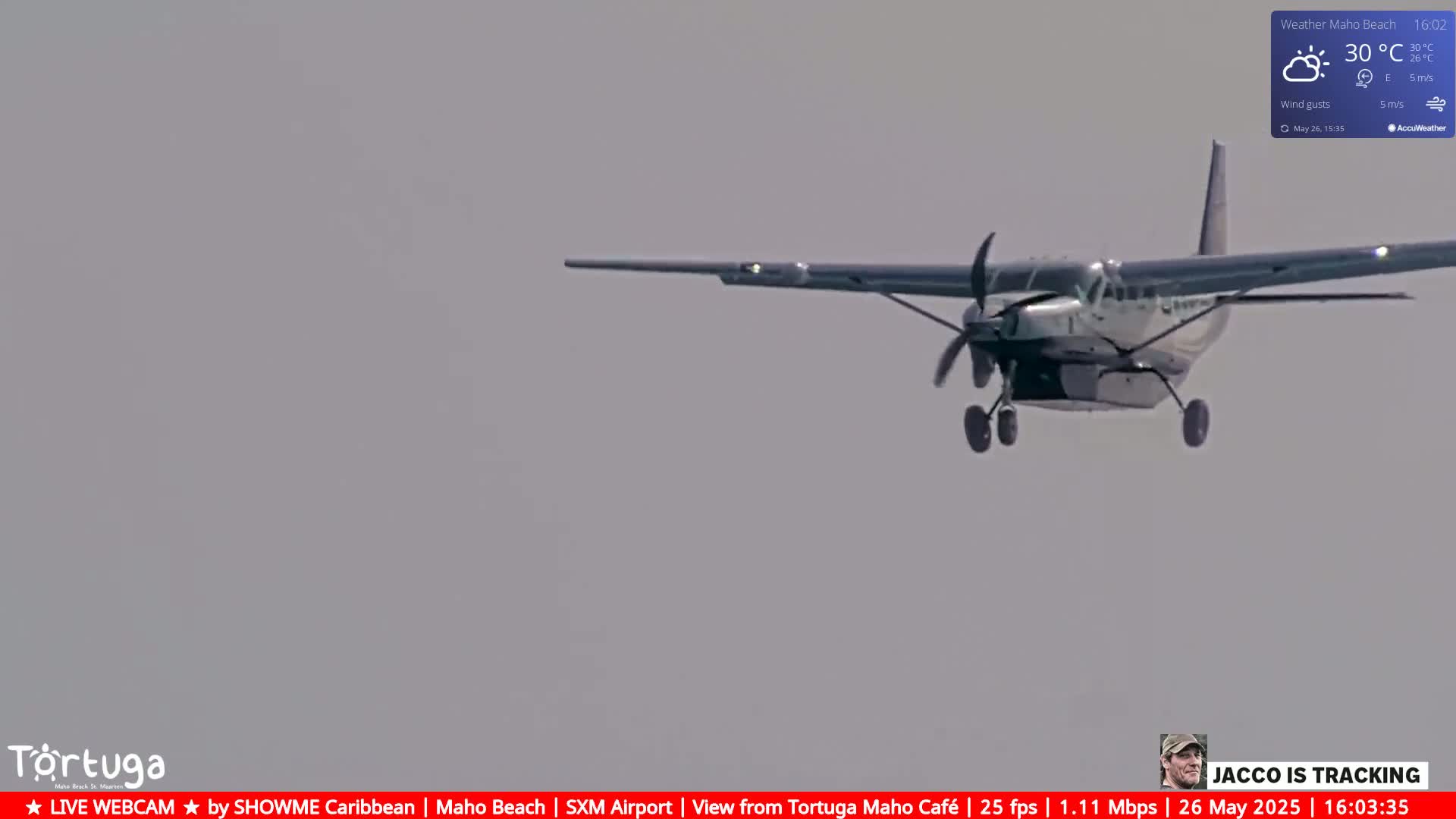 A small propeller airplane flies low in the sky under hazy, overcast conditions.