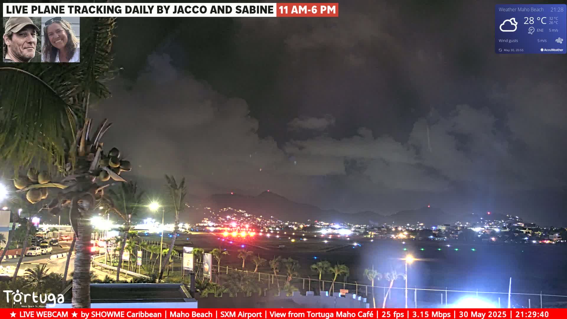A nighttime view of an airport runway and surrounding area, under a partly cloudy sky, with palm trees and lights visible in the foreground.