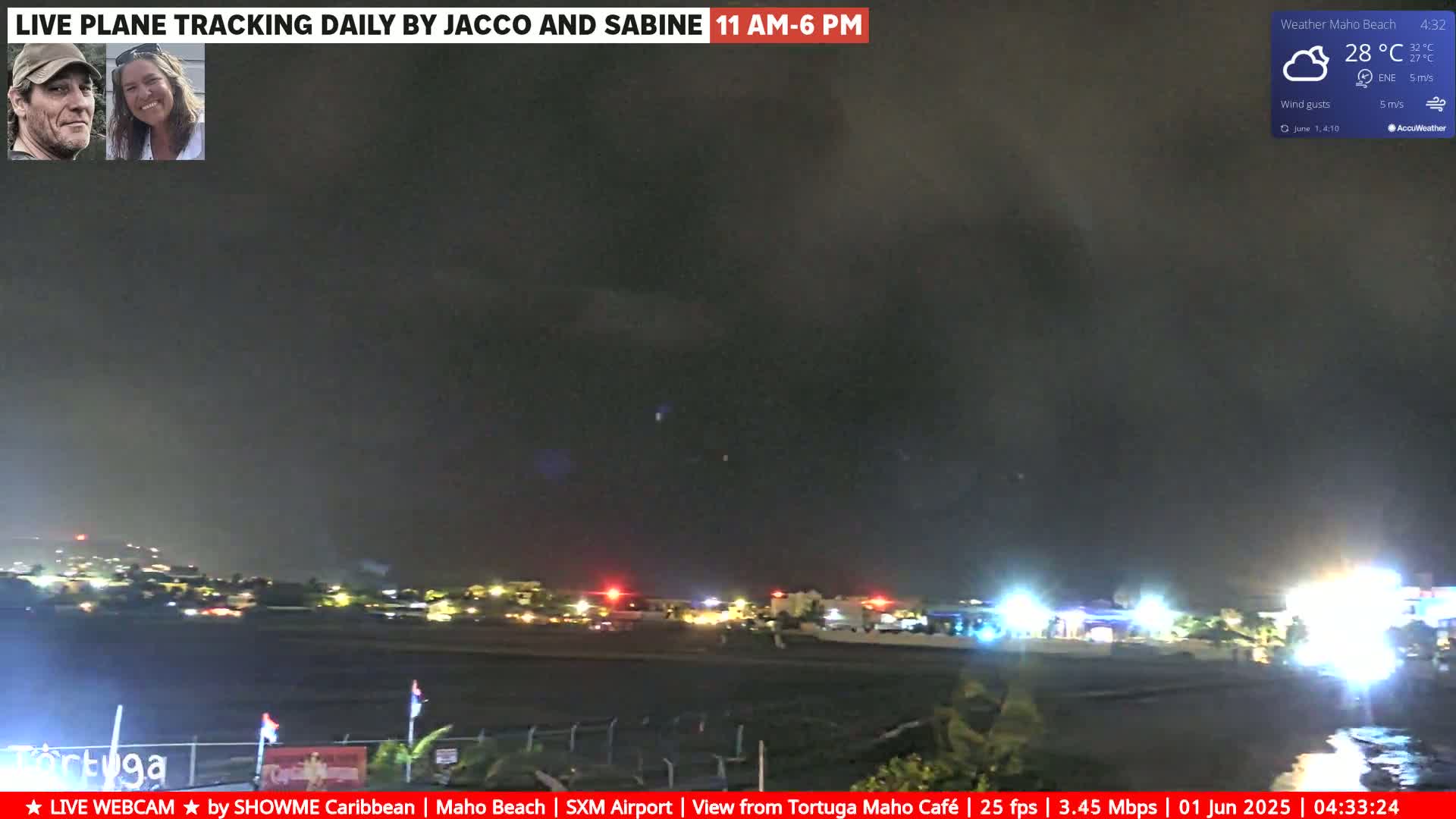 A nighttime view of an airport runway and surrounding area under a dark, cloudy sky.