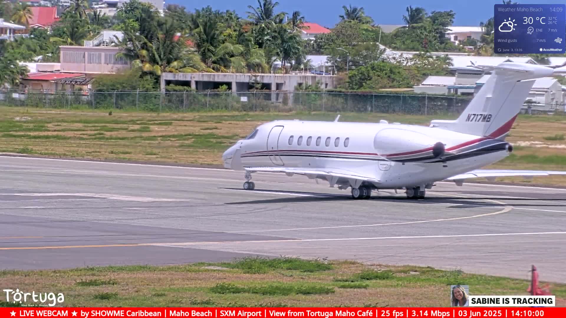 A white private jet taxis on an airport runway on a sunny day.