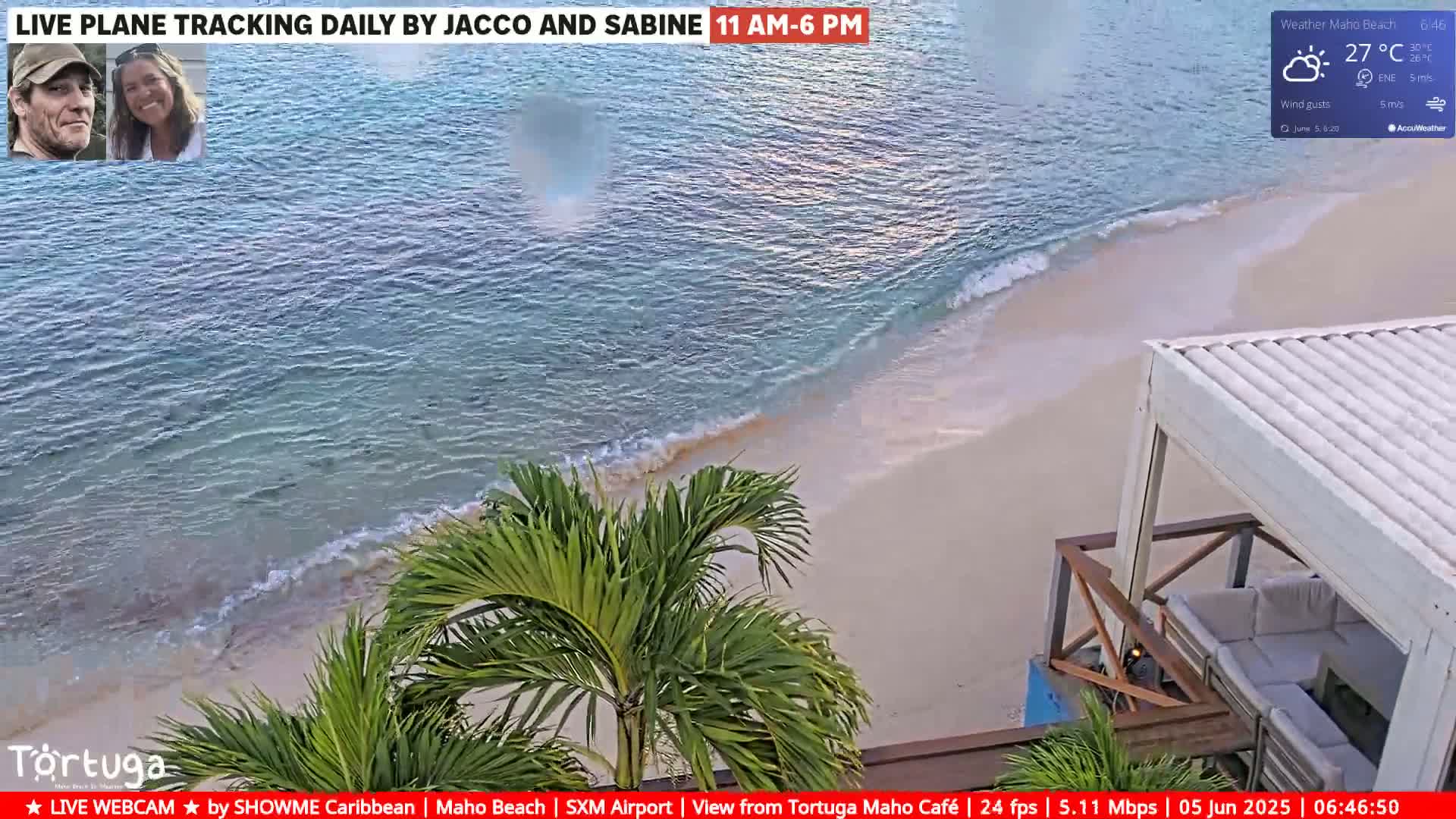 A sandy beach with light-blue water and small waves is partially visible from an elevated vantage point, under partly sunny skies with a temperature of 27°C.