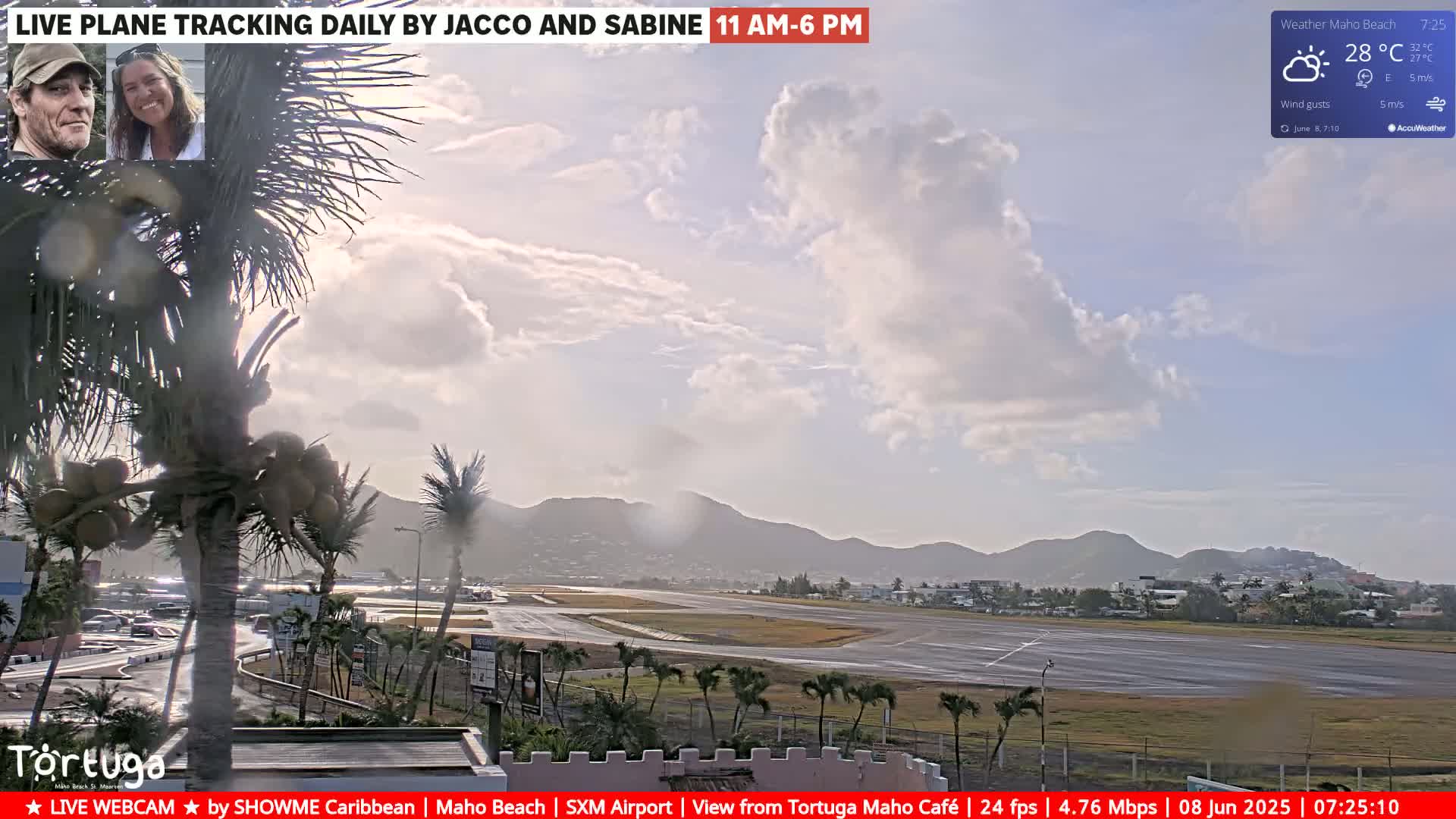 A mostly sunny day with partly cloudy skies and a light breeze shows an airport runway and surrounding palm trees, with distant hills in the background.