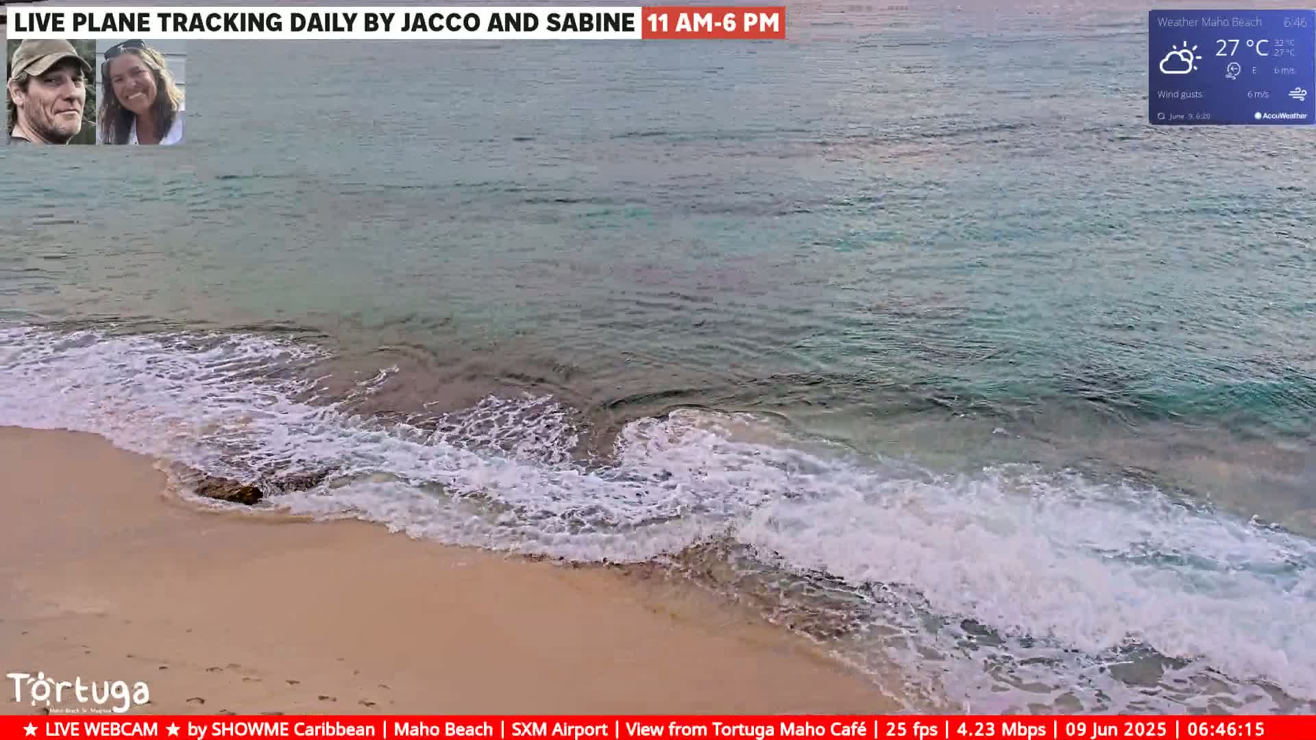 A sandy beach with small waves gently lapping the shore on a partly sunny day with a temperature of 27°C and light east winds.