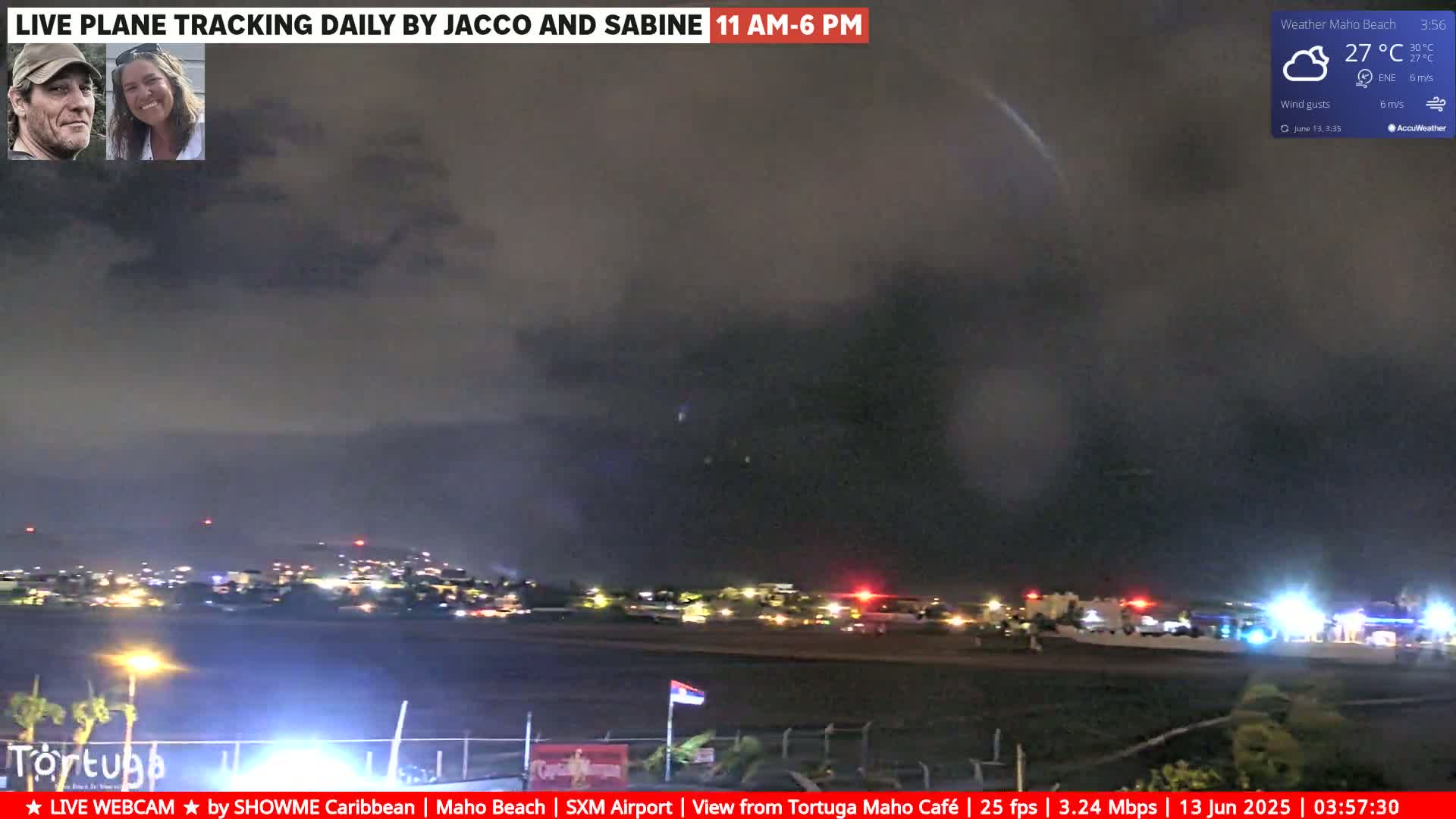 A nighttime view of an airport runway under a dark, cloudy sky with some lights visible on the ground.