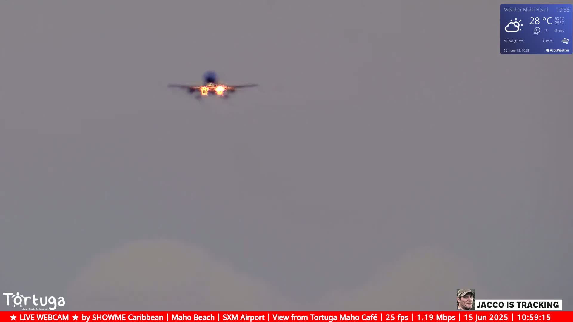 A low-flying airplane is approaching in a hazy sky with partly sunny weather conditions and a temperature of 28°C.