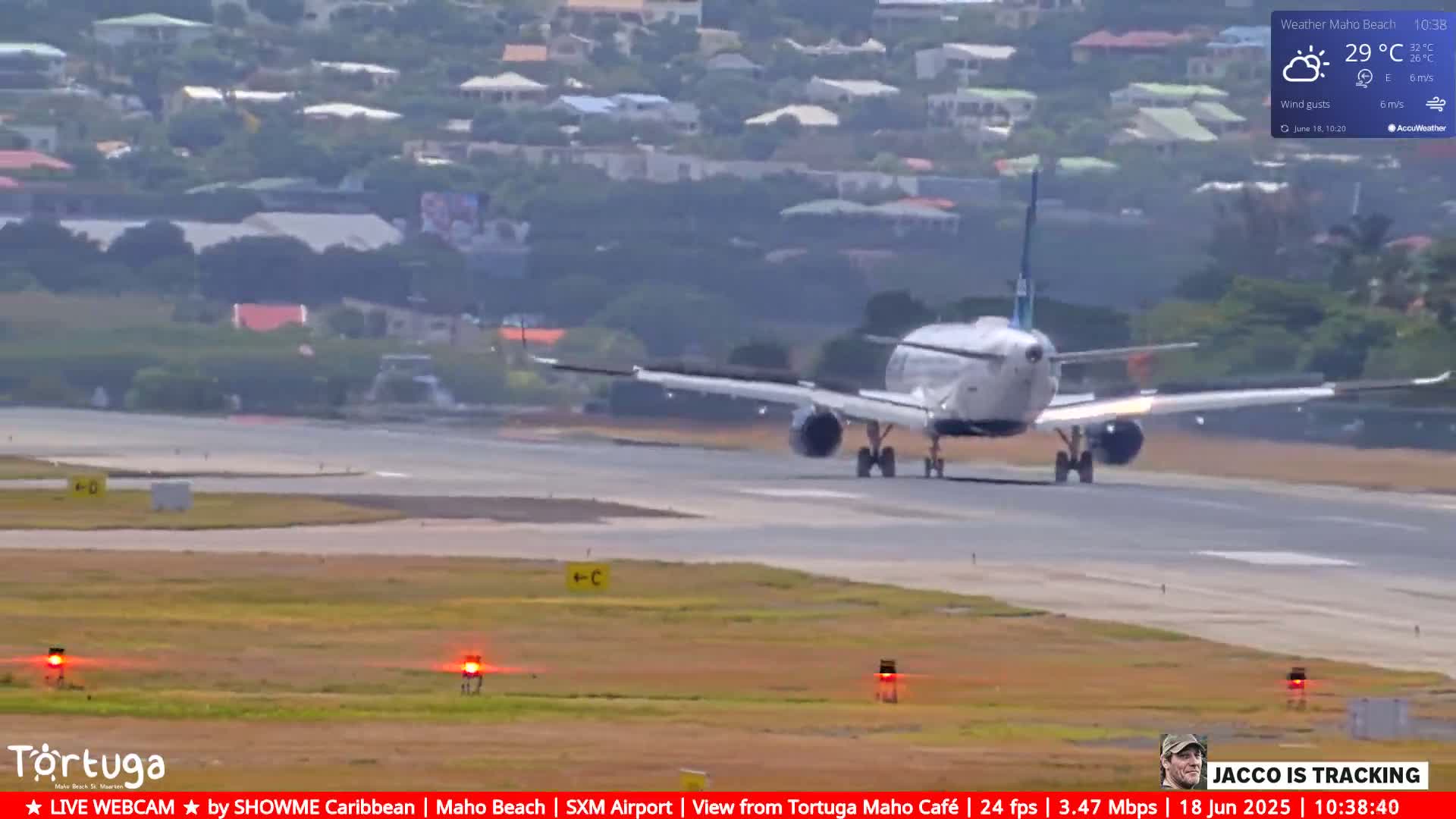 A passenger airplane is taxiing on an airport runway under partly cloudy skies.