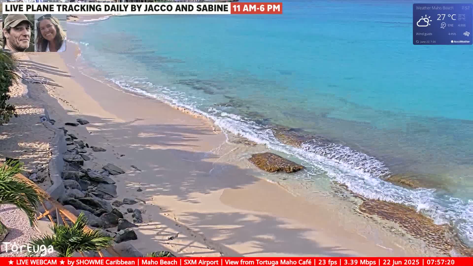 A sandy beach with turquoise water and small waves laps gently on the shore under sunny skies.