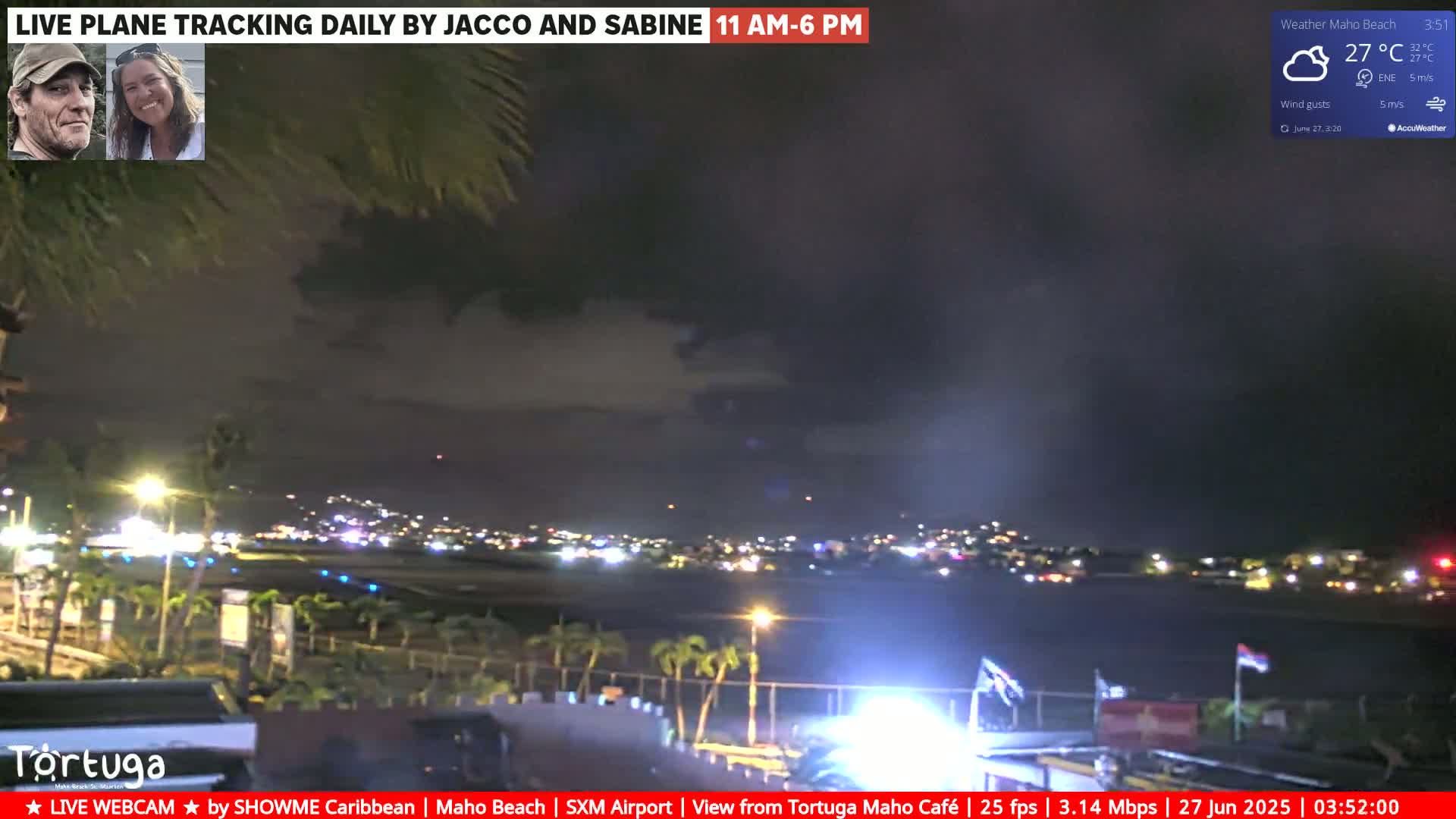 A nighttime view of an airport runway and surrounding area under a partly cloudy sky, with some lights visible in the distance.