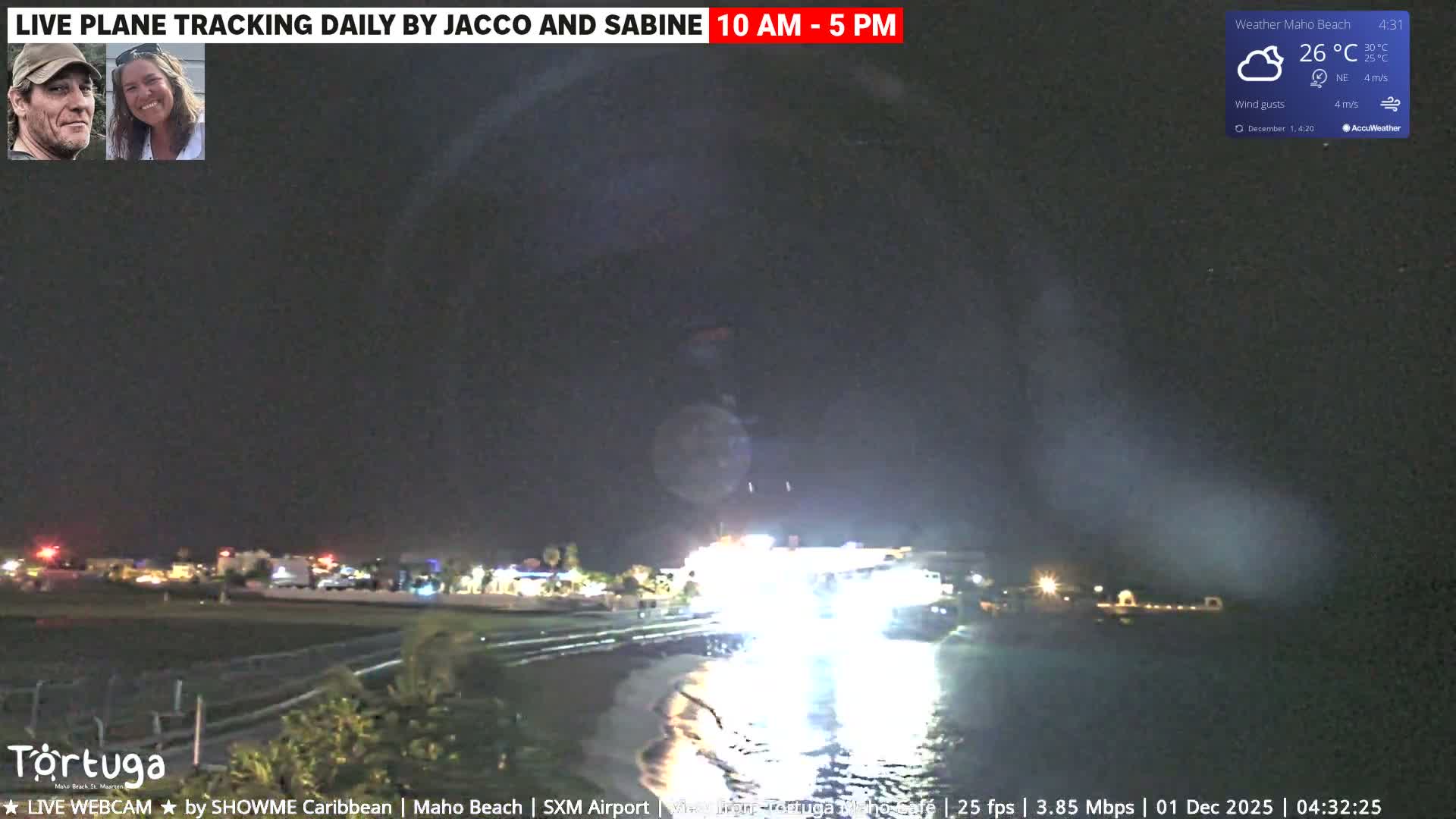 The image captures a vibrant nighttime coastal scene, with strong artificial lights from the shore reflecting intensely on the water under partly cloudy skies and a warm 26°C.