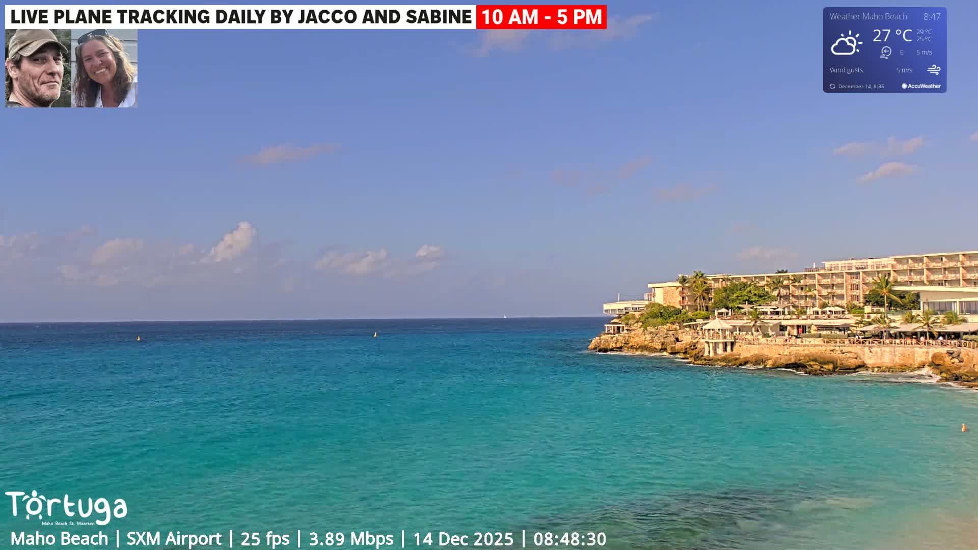 An evening view captures dark, rippling water reflecting numerous distant lights, with the corner of a structure visible in the foreground, under breezy conditions.