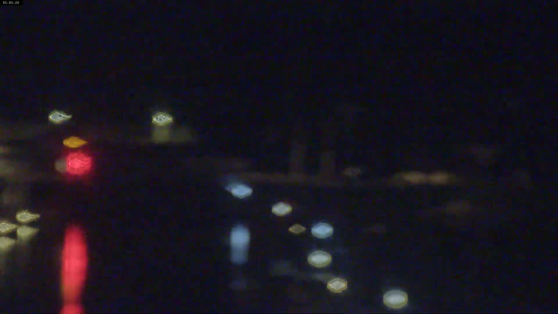 Blurred nighttime traffic lights are visible through rain-streaked glass.