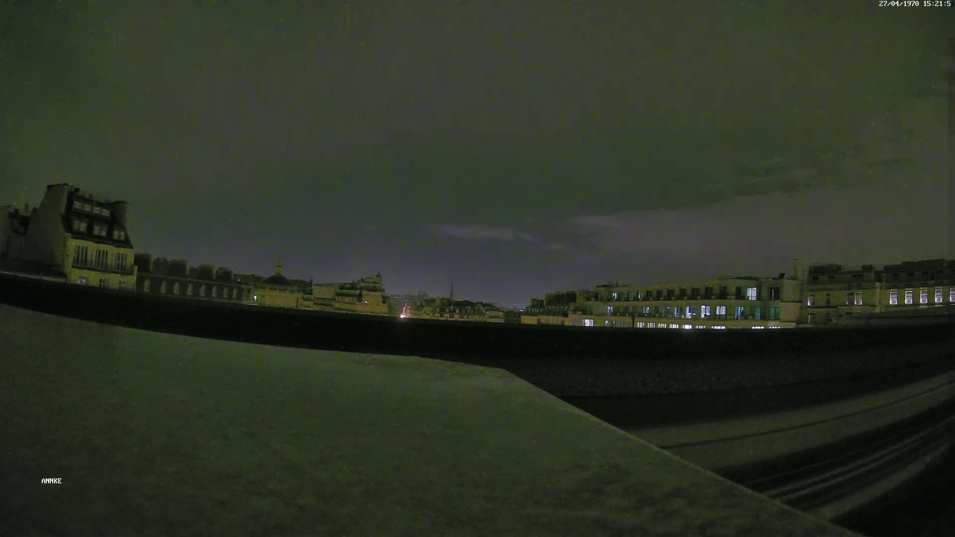 A nighttime view of city buildings under a dark, cloudy sky.