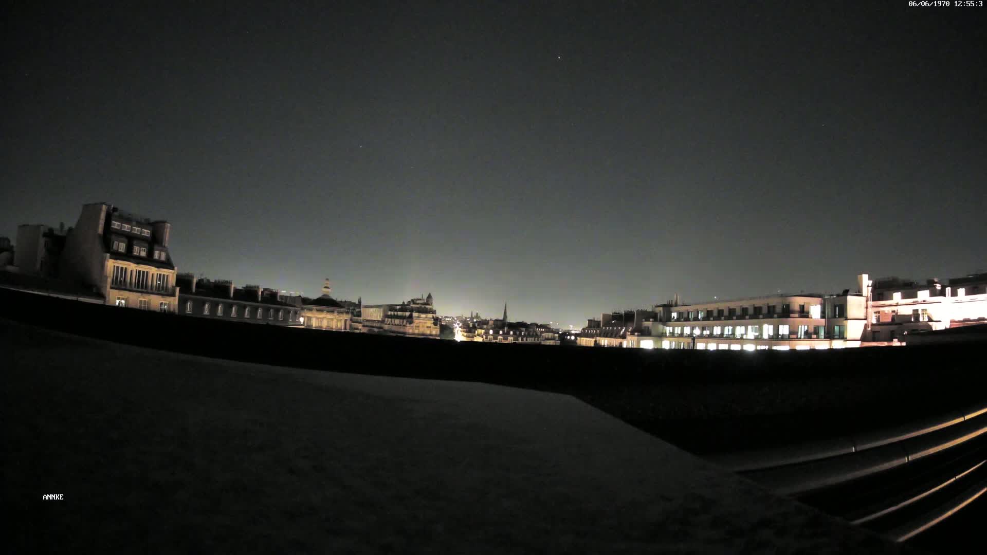 A nighttime cityscape of illuminated buildings under a clear, dark sky.