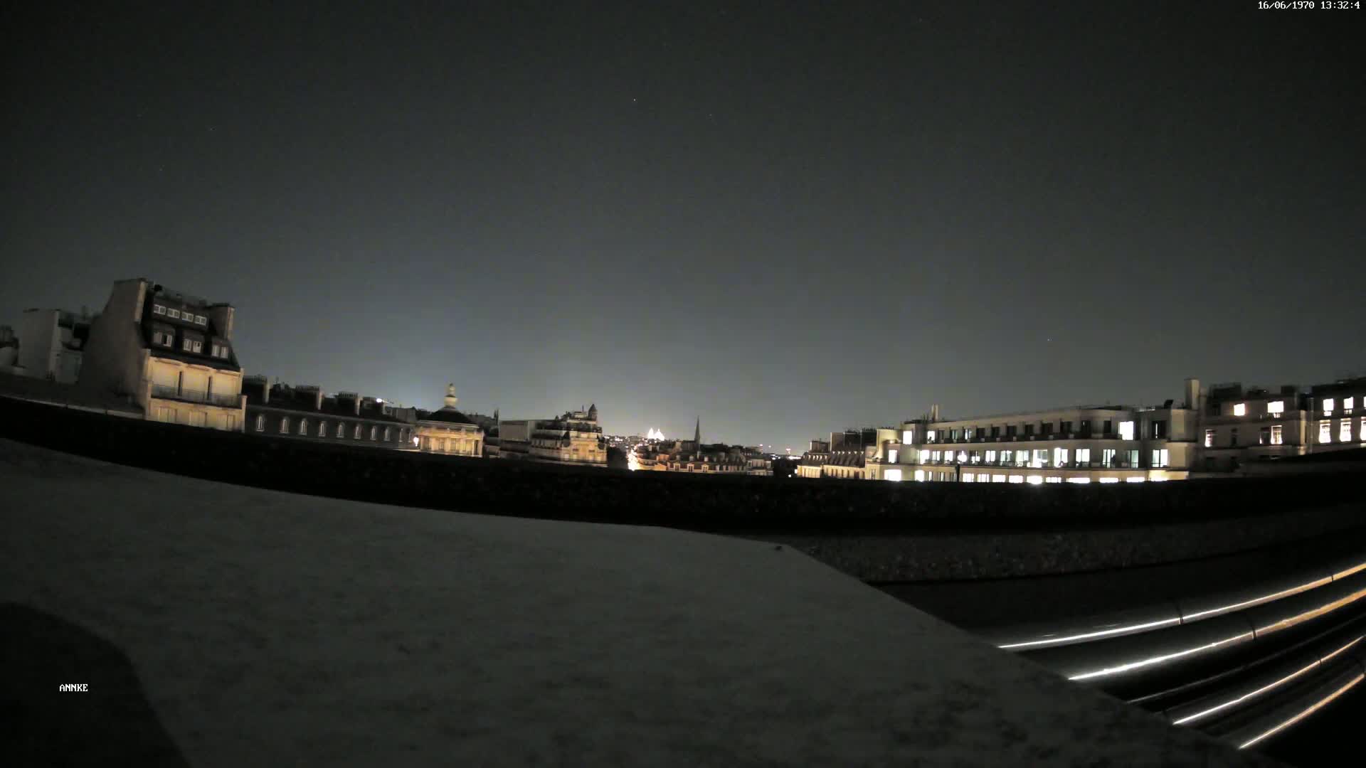 A nighttime cityscape view of illuminated buildings under a clear, dark sky.