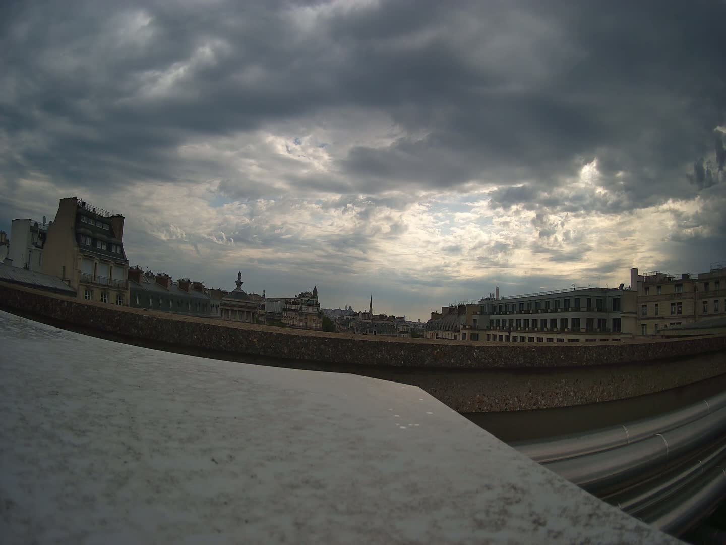 A cityscape of buildings under a cloudy sky.