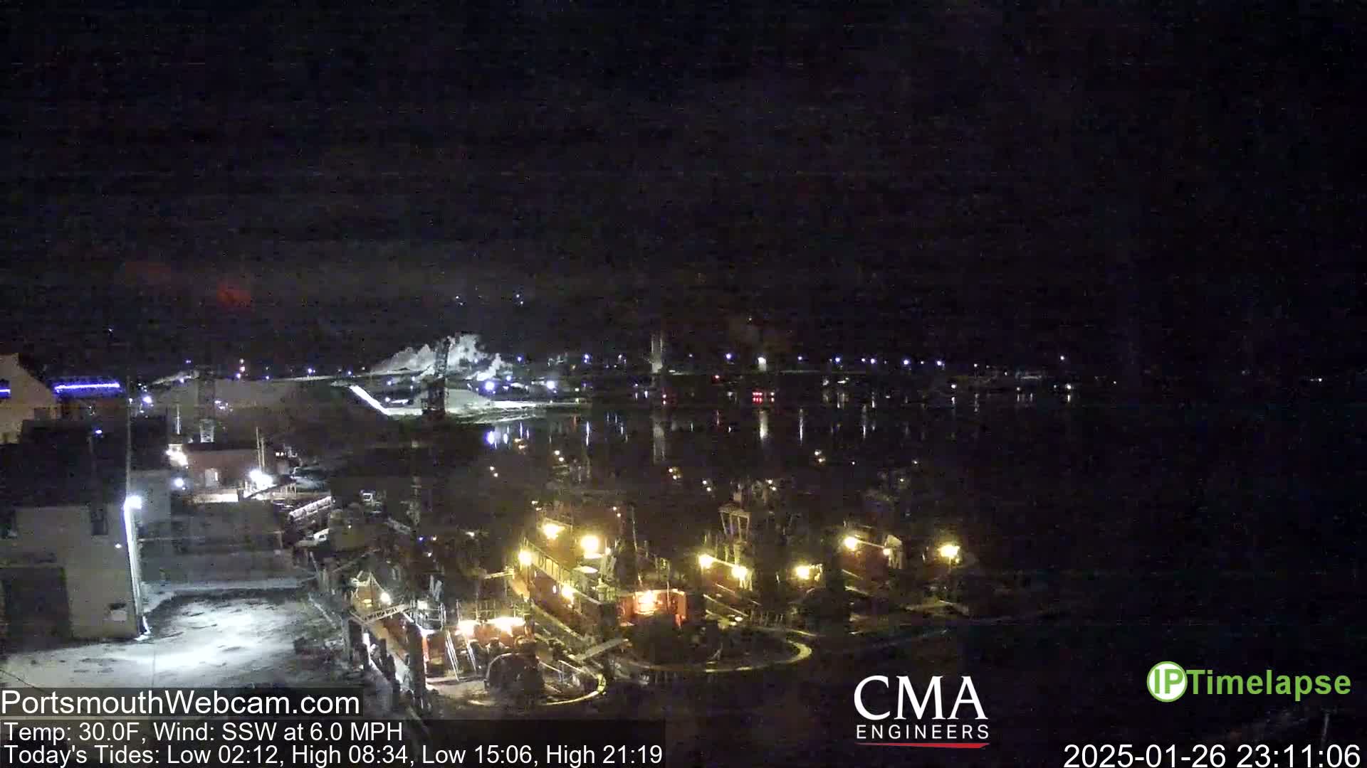 At night, several tugboats are docked at a waterfront area under a clear, dark sky with a 30°F temperature and a 6 mph south-southwest wind.