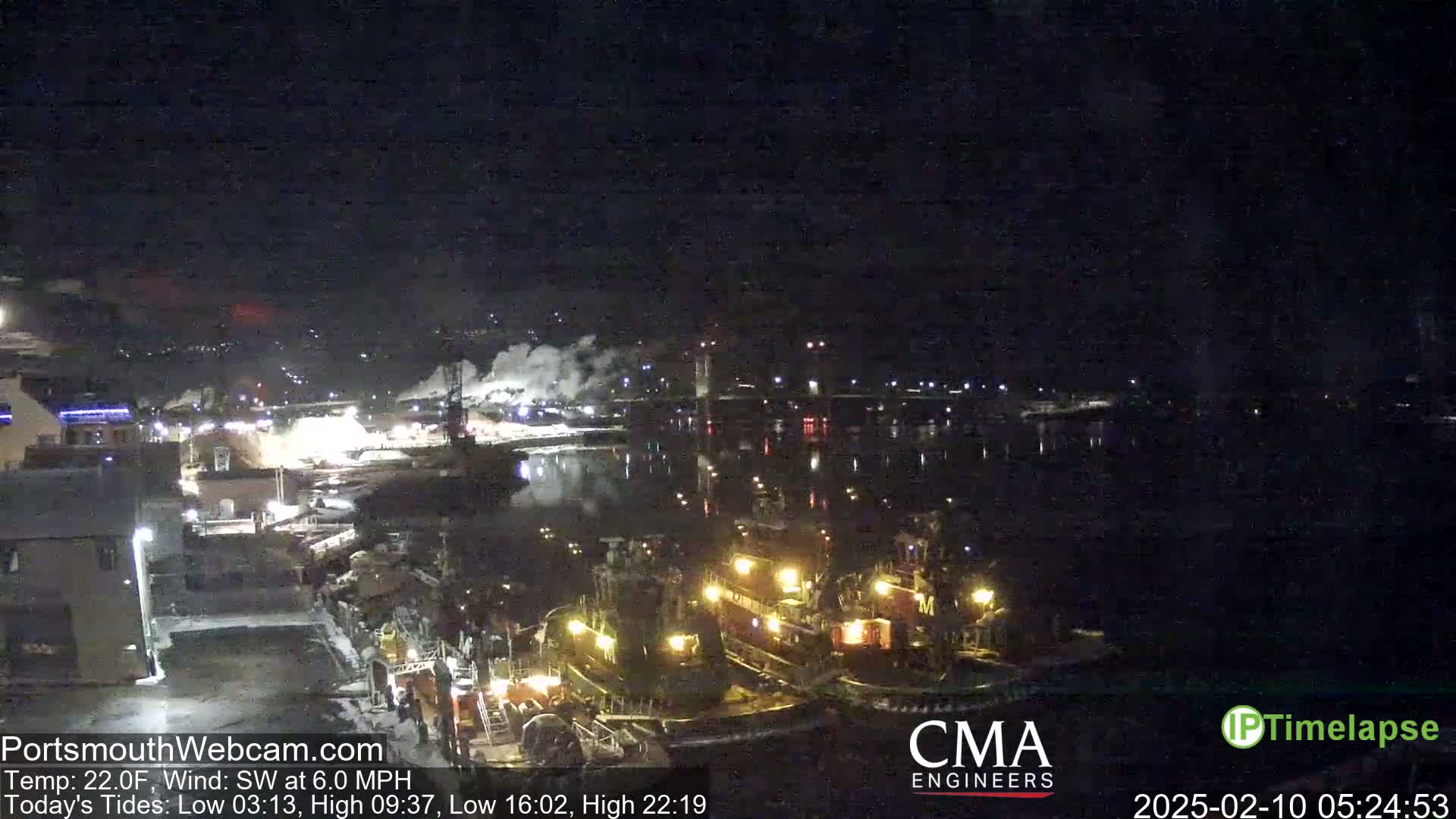 Several tugboats are docked at a nighttime harbor under a clear, dark sky with a southwest wind.