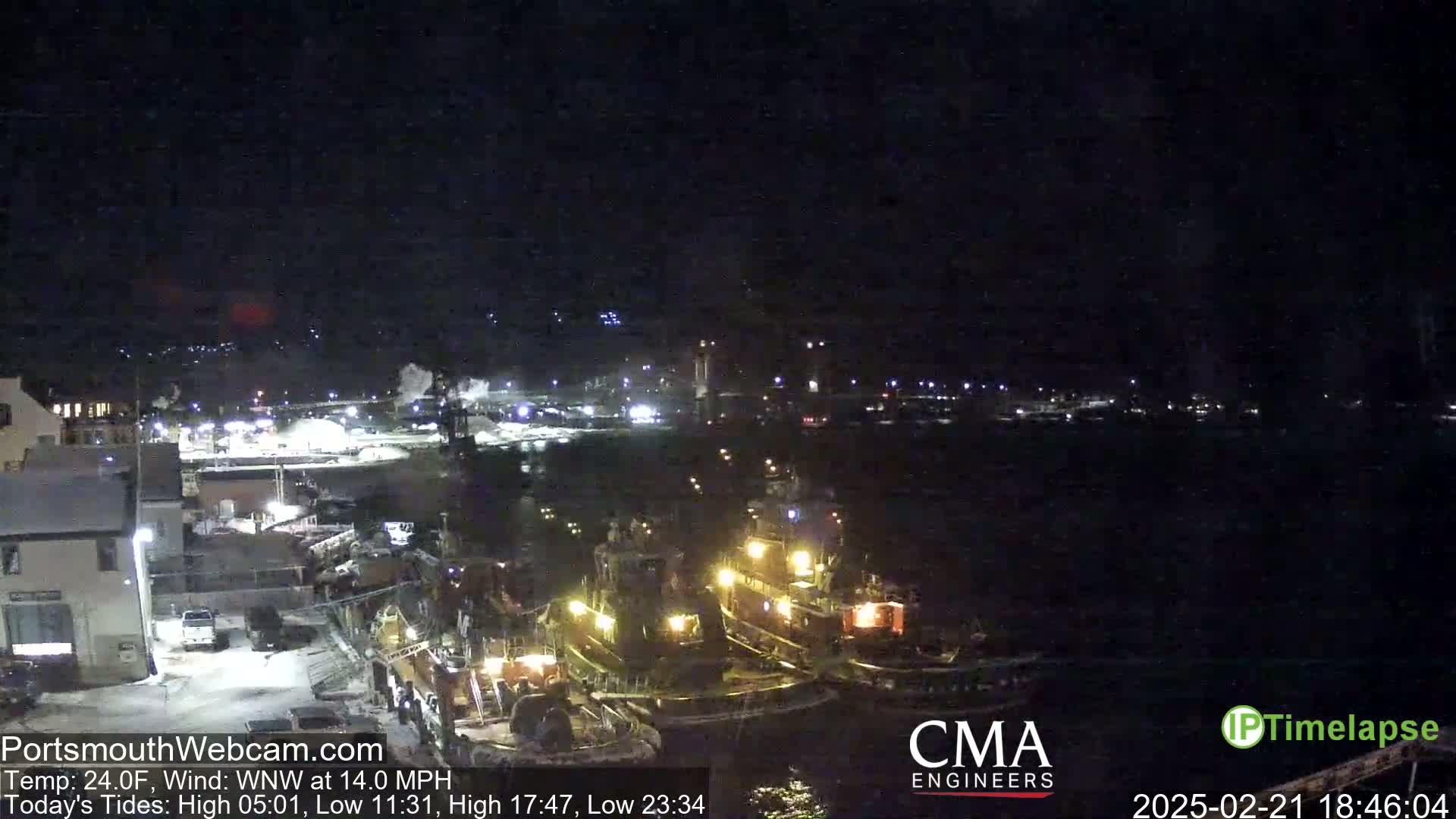 Several tugboats are moored at a dock at night in a 24°F temperature with a 14 mph wind from the west-northwest.