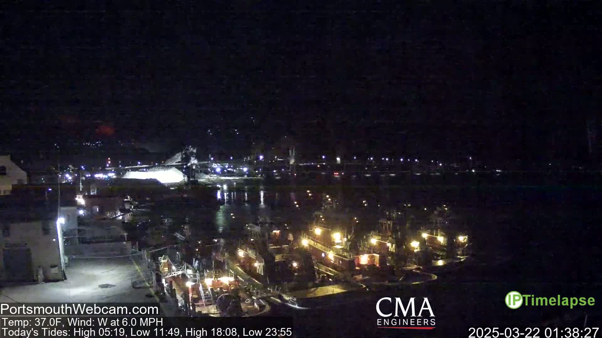 Several tugboats are docked at a nighttime harbor under a clear, dark sky with a 37°F temperature and a 6 mph westerly wind.