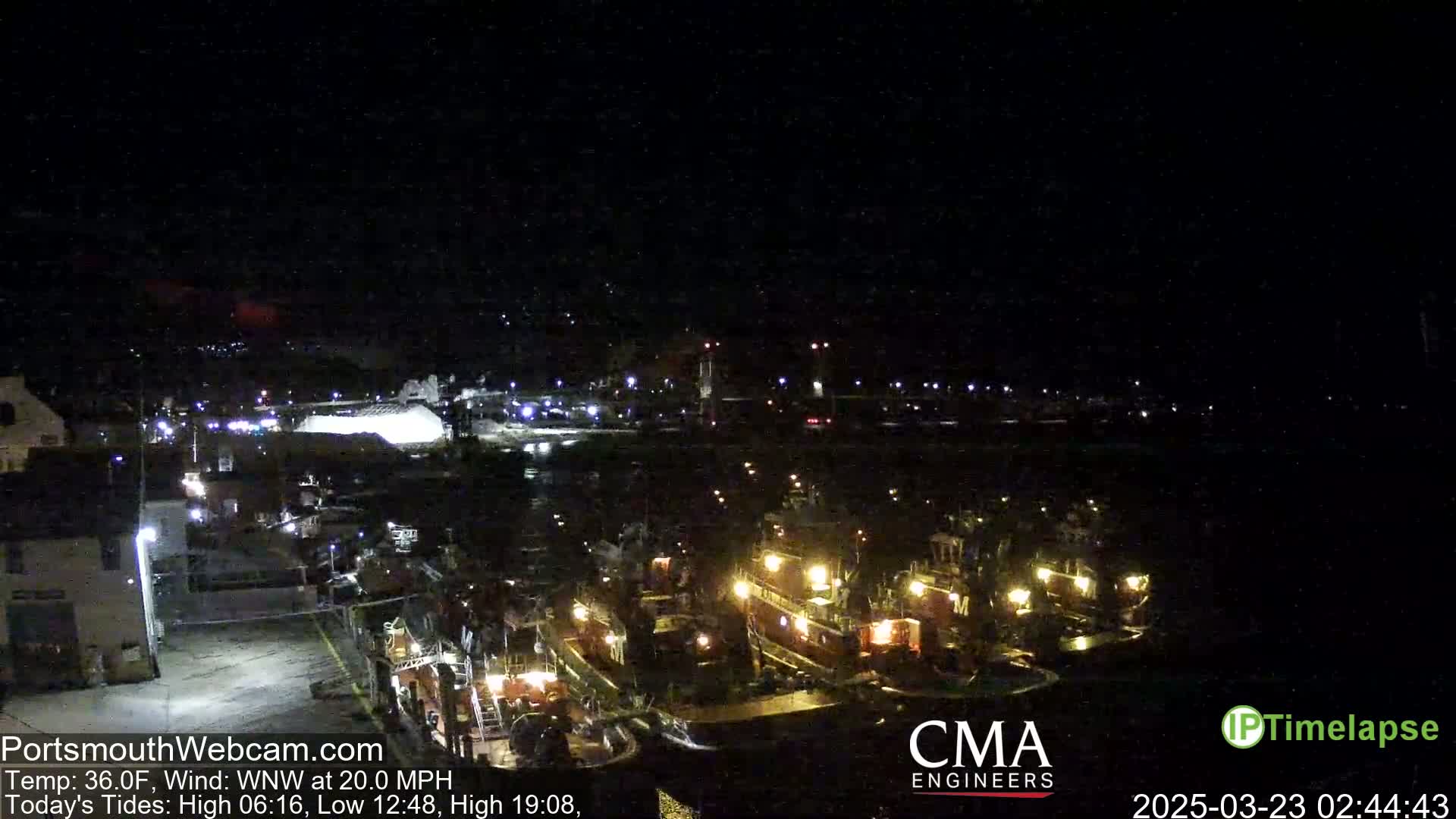 Several tugboats are docked at a harbor at night under a dark sky with a WNW wind at 20 mph and a temperature of 36°F.
