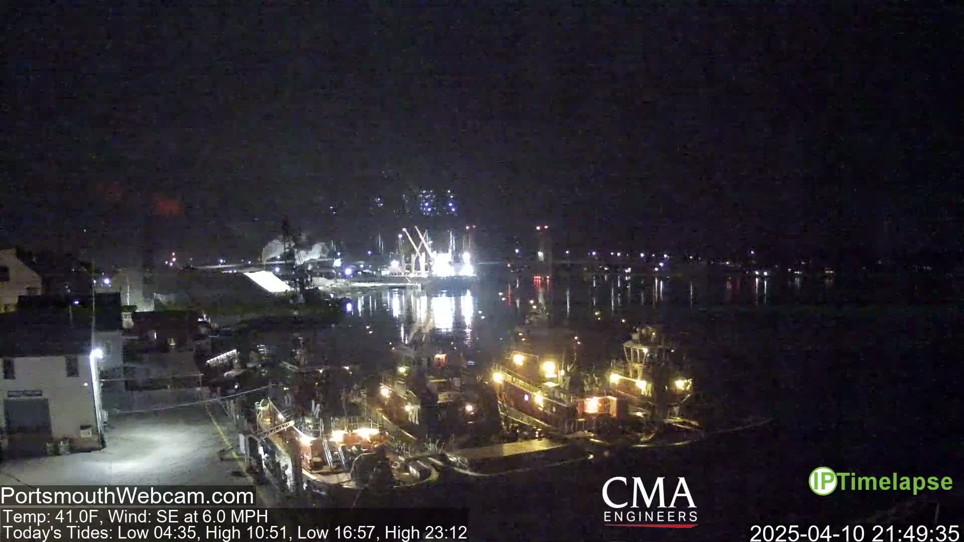 Several tugboats are moored at a dock at night under a dark, clear sky with a southeast wind.