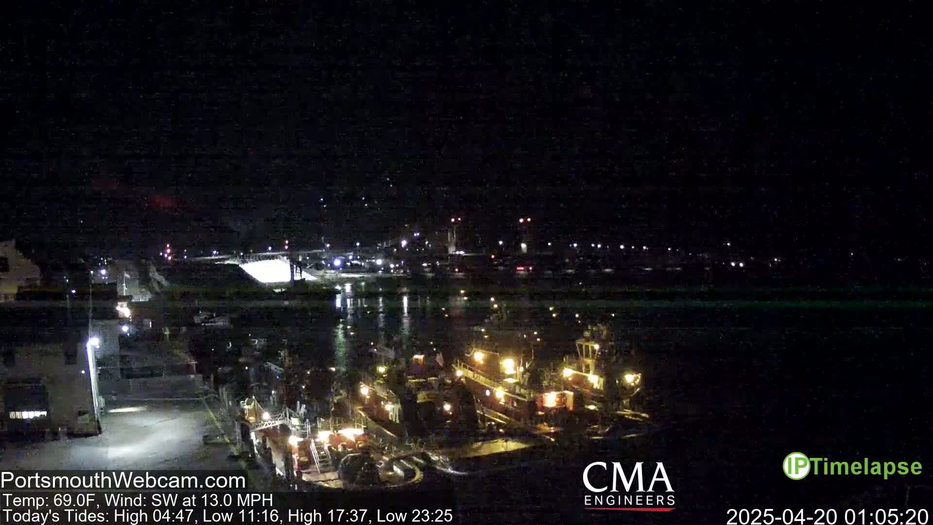 Several tugboats are docked at a harbor at night under a dark, clear sky with a southwest wind.