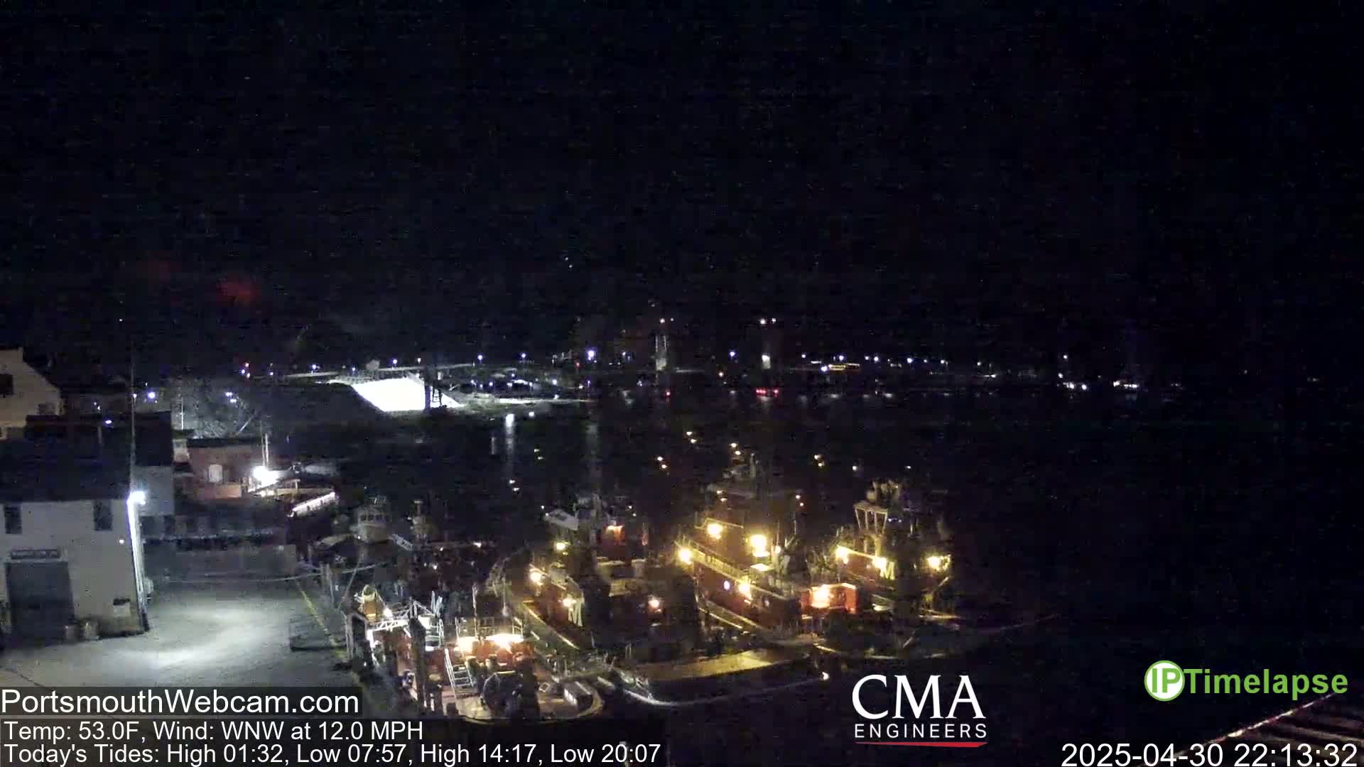 Several tugboats are docked at a nighttime harbor under a clear, dark sky with a 12 mph wind.